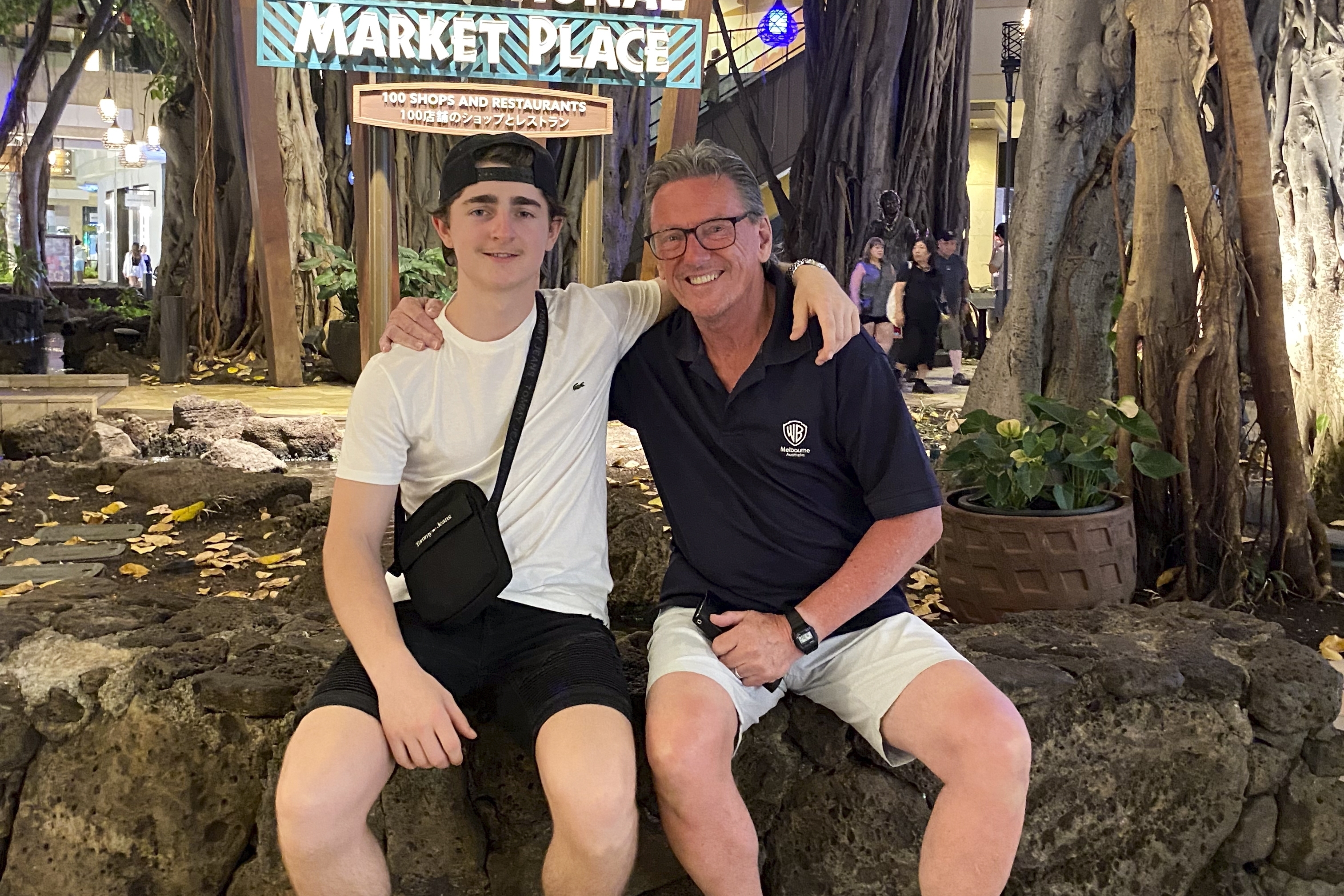 In this October 2023 photo provided by the Holdsworth family, Wayne Holdsworth sits with his son Mac on a family holiday in Hawaii. (Maggie Holdsworth via AP)