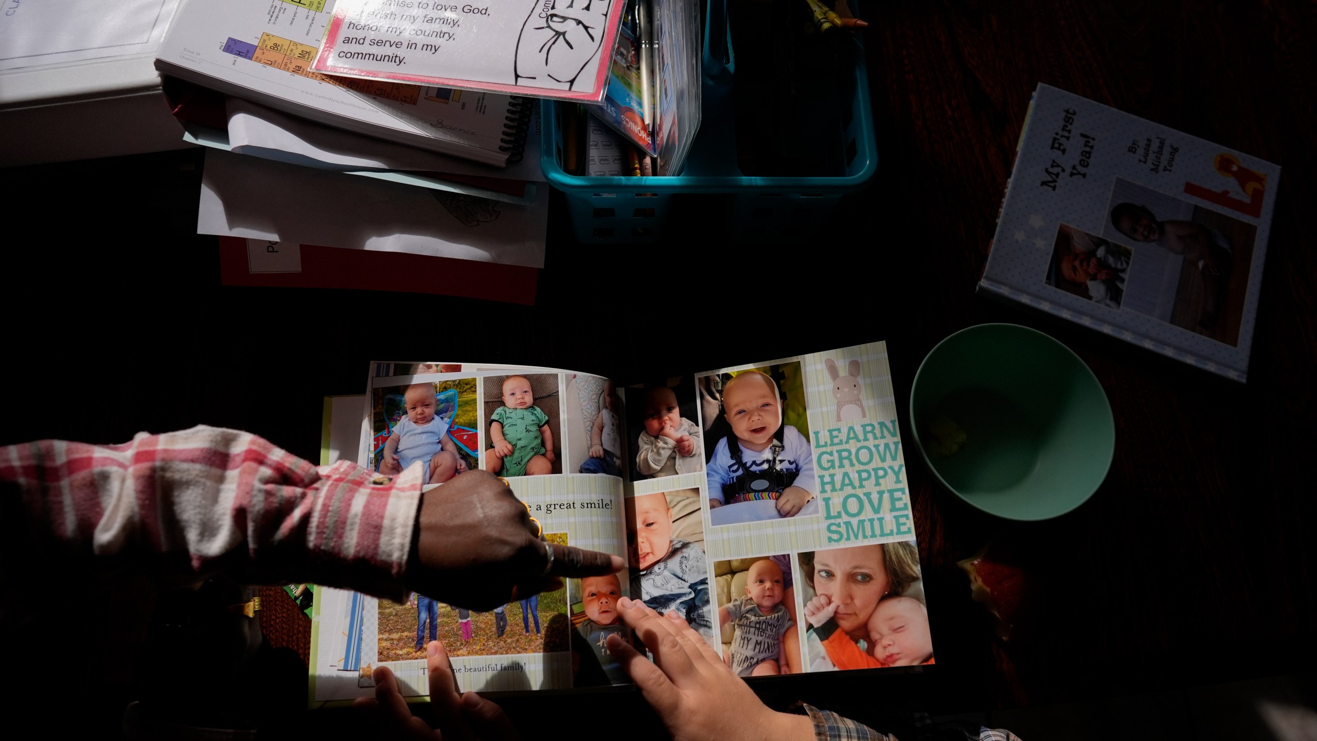 Isaac Young, 5, right, and his big sister Gianna Young, 7, look at his one-year baby book during a homeschool break in the dining room of their Sunbury, Ohio, home on Tuesday, Nov. 12, 2024. (AP Photo/Carolyn Kaster)