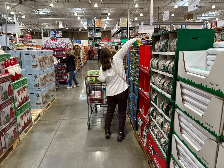 FILE - Shoppers reach for items on display in a Costco warehouse Nov. 19, 2024, in Lone Tree, Colo. (AP Photo/David Zalubowski, File)