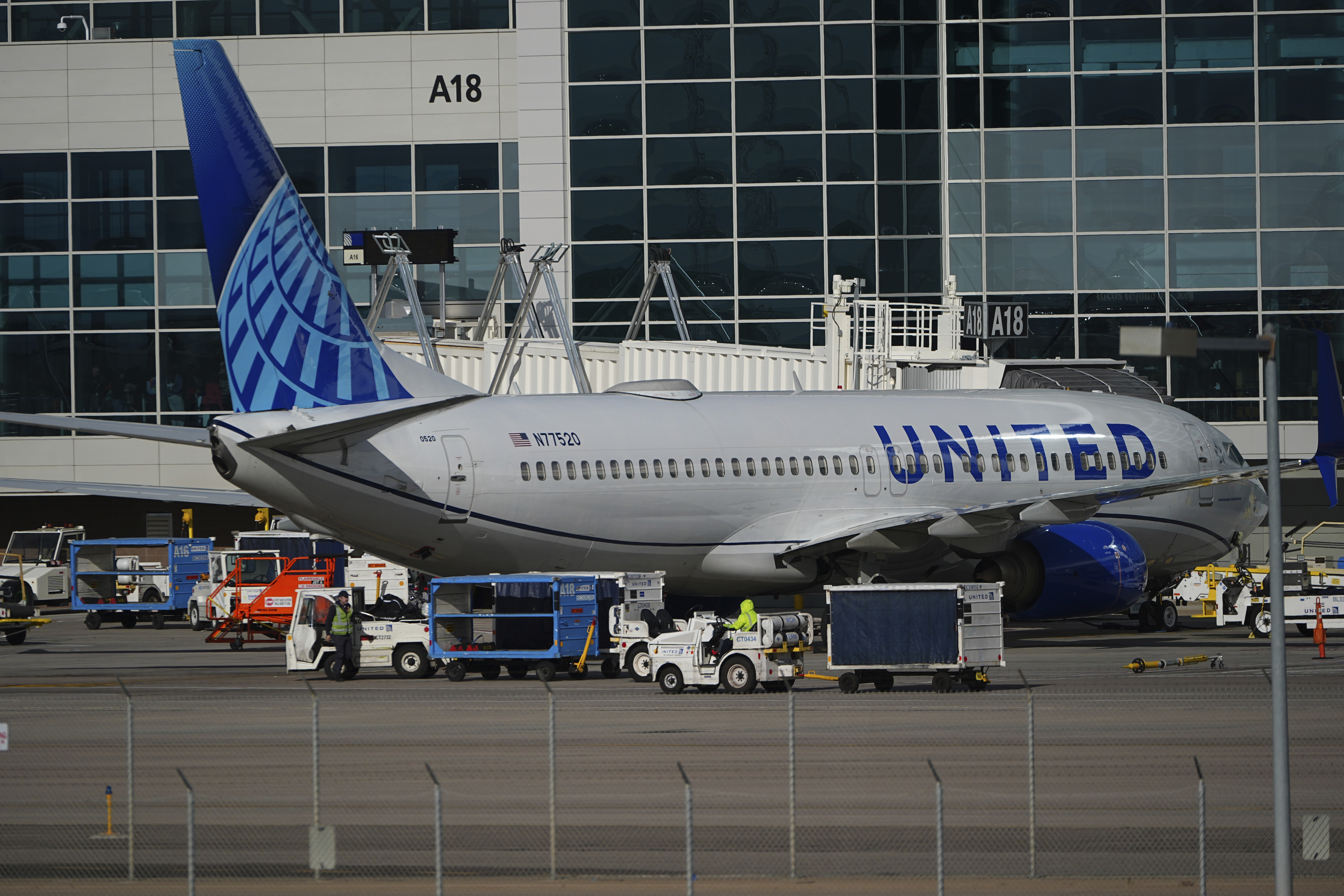 Workers prepare a United Airlines jetliner for departure from a gate on the A concourse at Denver International Airport Tuesday, Nov. 26, 2024, in Denver. (AP Photo/David Zalubowski)