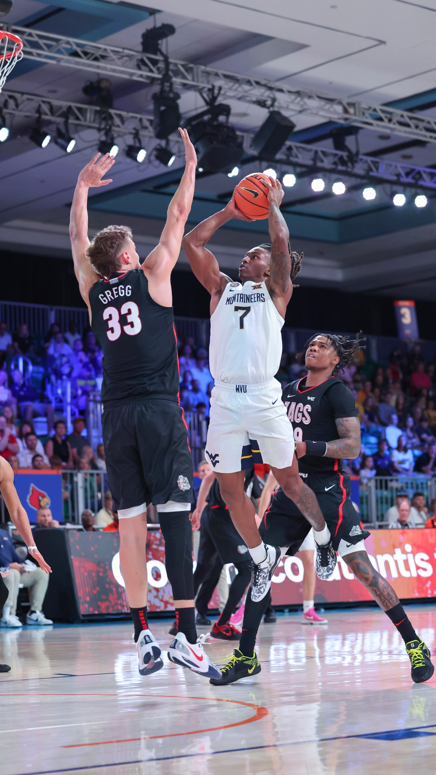 In this handout provided by Bahamas Visual Services, West Virginia guard Javon Small (7) takes a shot as Gonzaga forward Ben Gregg (33) defends during an NCAA college basketball game at the Battle 4 Atlantis tournament in Paradise Island, Bahamas Wednesday, Nov. 27, 2024. (Tim Aylen/Bahamas Visual Services via AP)