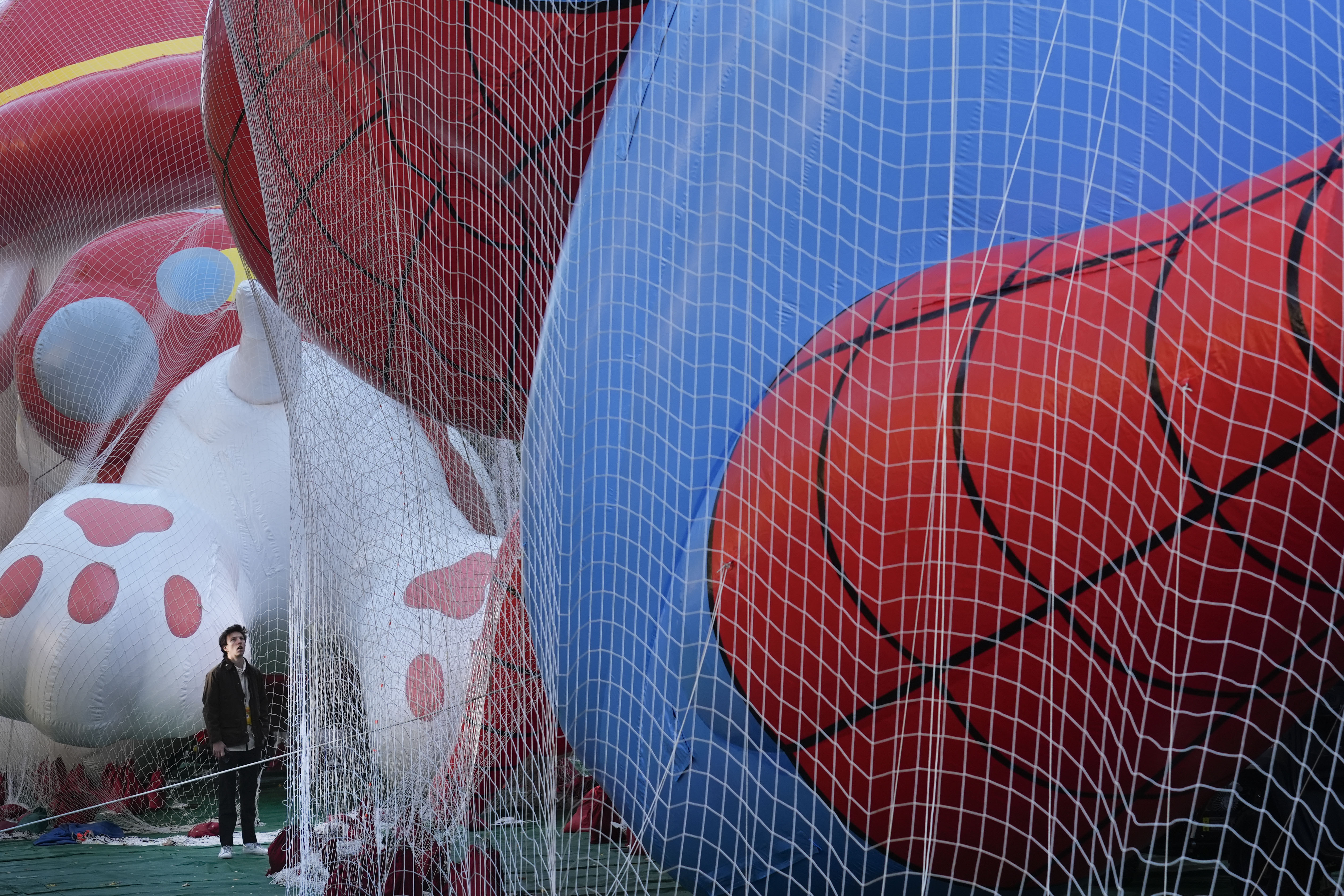 A man looks up at floats being prepared for the Macy's Thanksgiving Day Parade in New York, Wednesday, Nov. 27, 2024. (AP Photo/Seth Wenig)