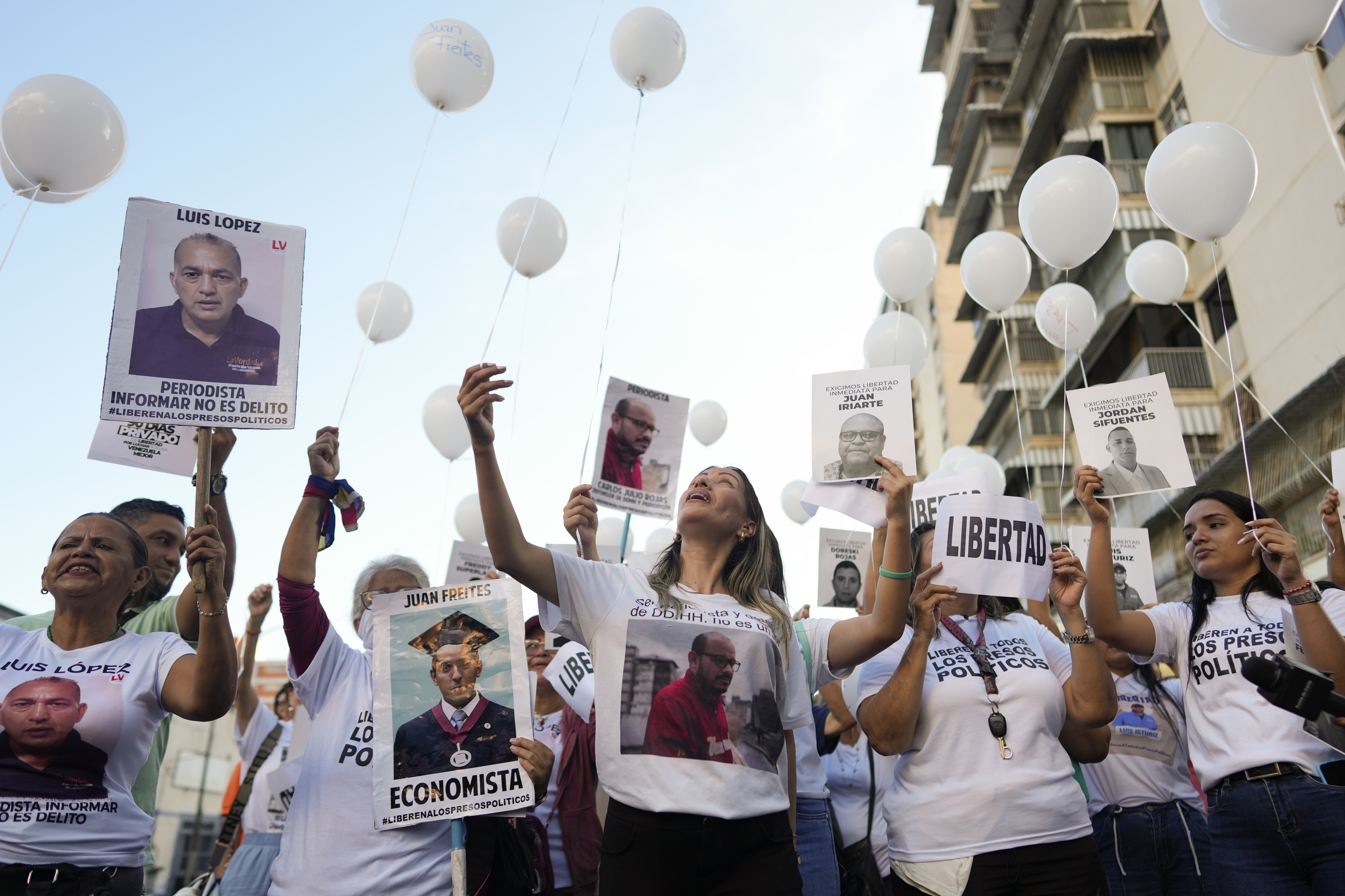 Relatives of detainees release balloons during a vigil calling for the freedom of political prisoners near the headquarters of the National Intelligence Service (SEBIN) in Caracas, Venezuela, Wednesday, Nov. 27, 2024. (AP Photo/Ariana Cubillos)