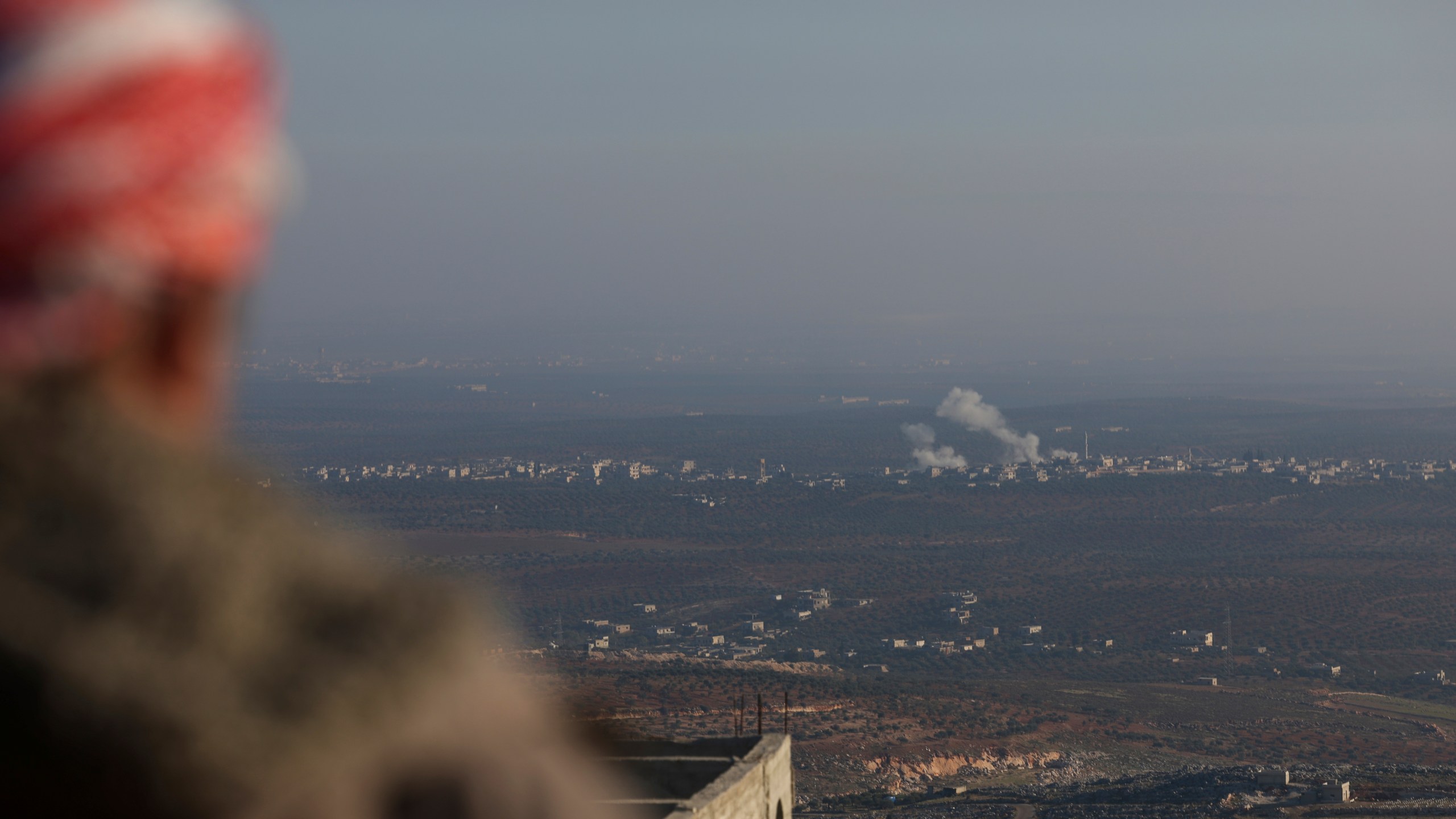 CORRECTS CITY Smoke rises amid fighting between opposition factions and Syrian government troops in Majdaliya, Idlib countryside, Syria, Thursday, Nov. 28, 2024. (AP Photo/Ghaith Alsayed)