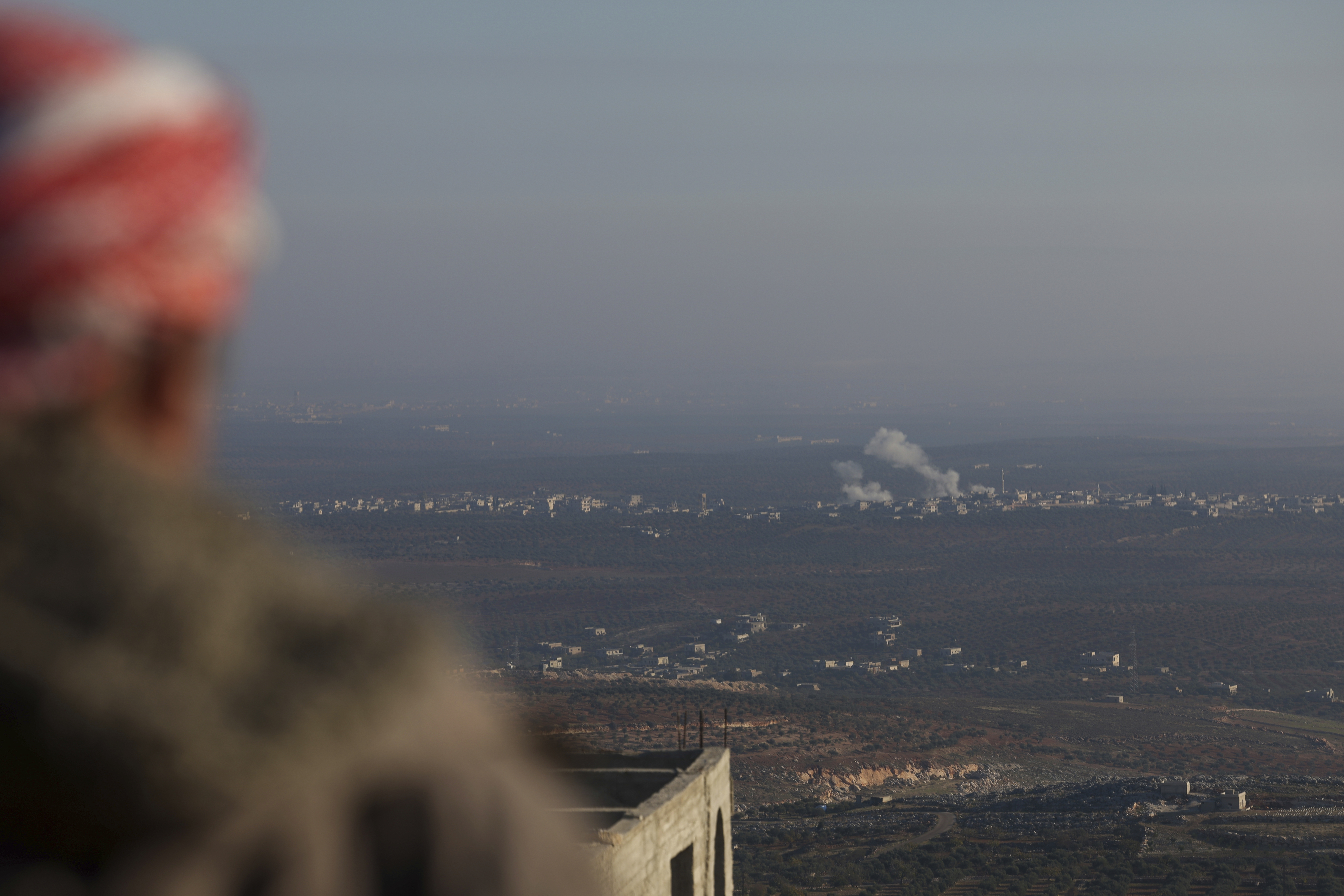 CORRECTS CITY Smoke rises amid fighting between opposition factions and Syrian government troops in Majdaliya, Idlib countryside, Syria, Thursday, Nov. 28, 2024. (AP Photo/Ghaith Alsayed)