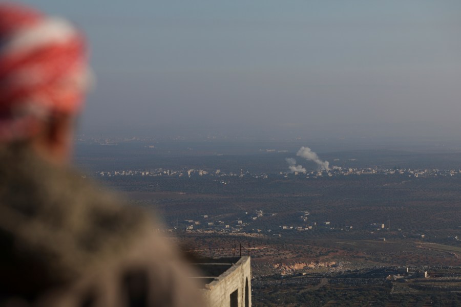 CORRECTS CITY Smoke rises amid fighting between opposition factions and Syrian government troops in Majdaliya, Idlib countryside, Syria, Thursday, Nov. 28, 2024. (AP Photo/Ghaith Alsayed)