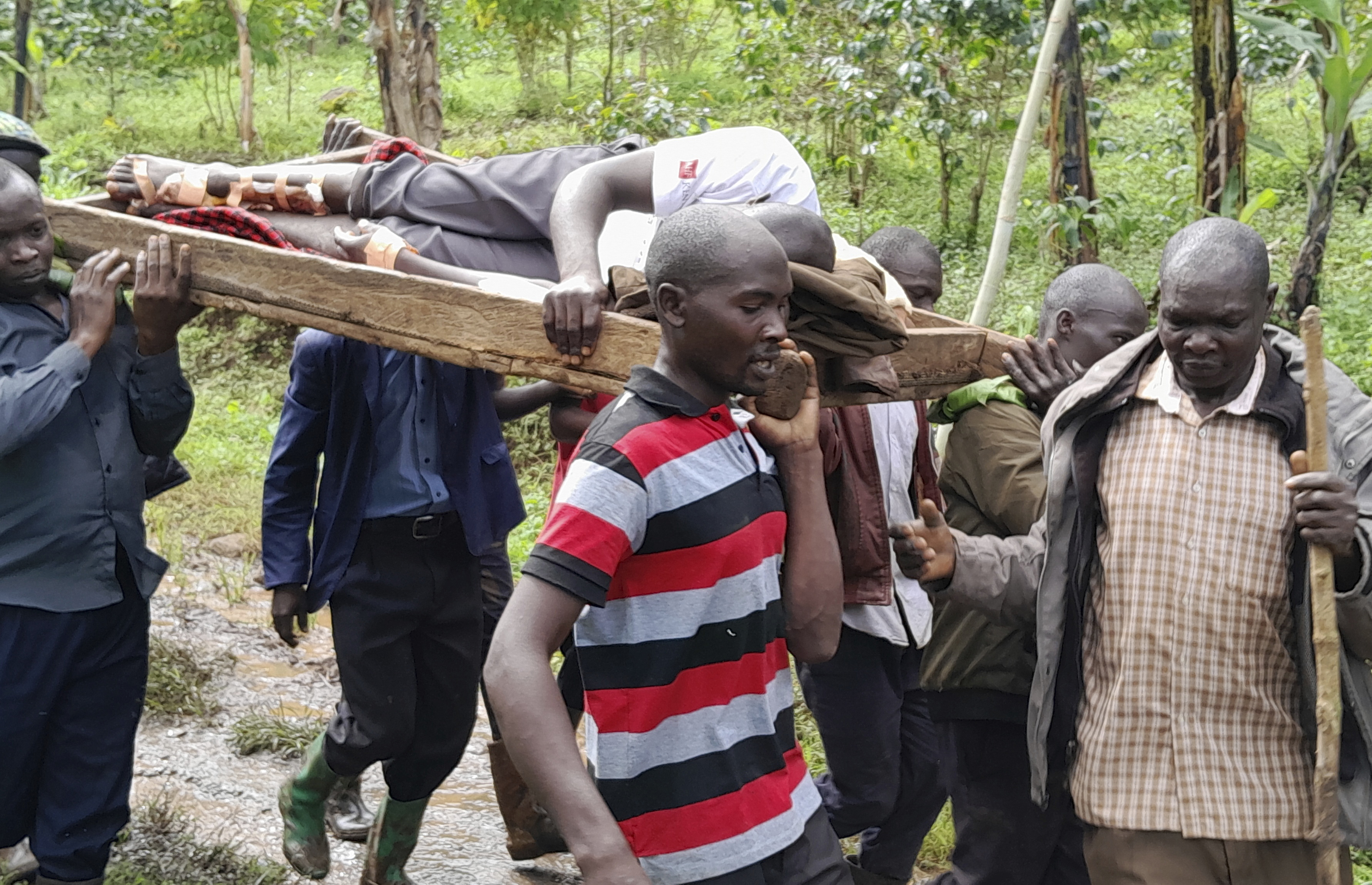 Rescue workers carry an injured man after landslides following heavy rains buried 40 homes in the mountainous district of Bulambuli, eastern Uganda, Thursday, Nov. 28. 2024. (AP Photo/Jean Watala)