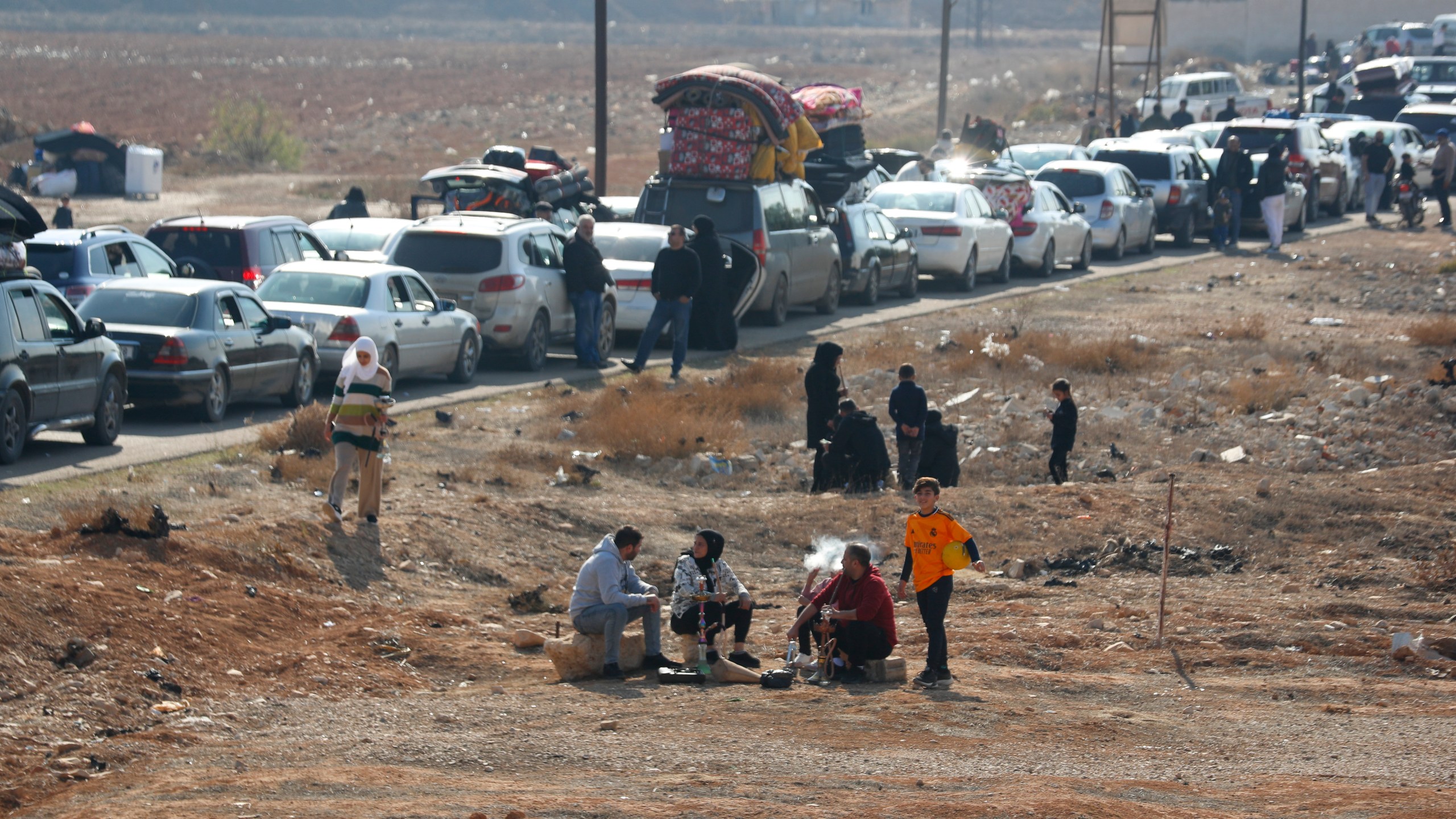 Lebanese families sit in traffic as they return to Lebanon through the Jousieh border crossing, in Qusair, Syria, Thursday, Nov. 28, 2024, following a ceasefire between Israel and Hezbollah that went into effect on Wednesday. (AP Photo/Omar Sanadiki)