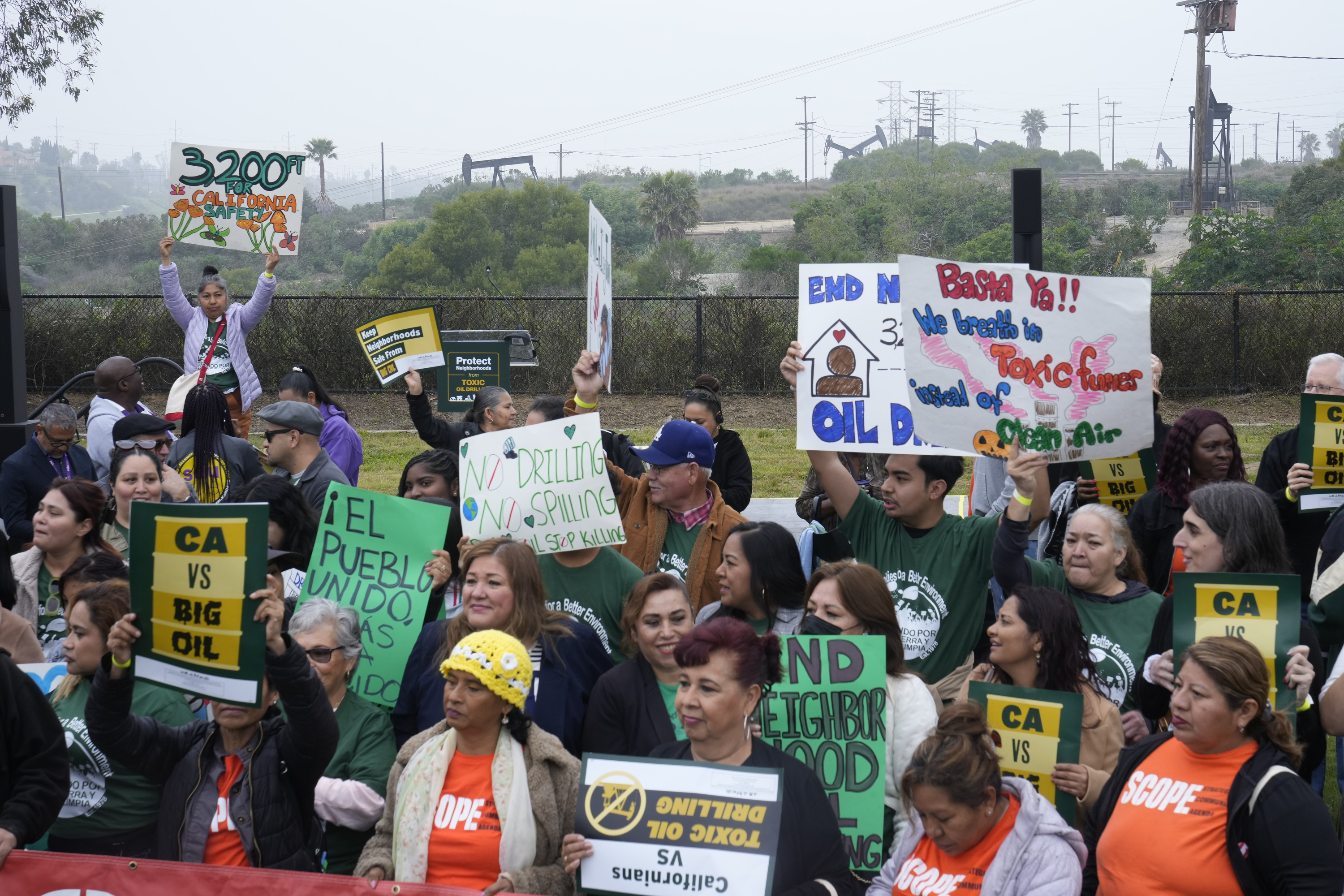 FILE - Members of Campaign for a Safe and Healthy California coalition campaign for Keep The Law (SB 1137) next to the Inglewood Oil Field in Inglewood, Calif., March. 22, 2024. (AP Photo/Damian Dovarganes, File)