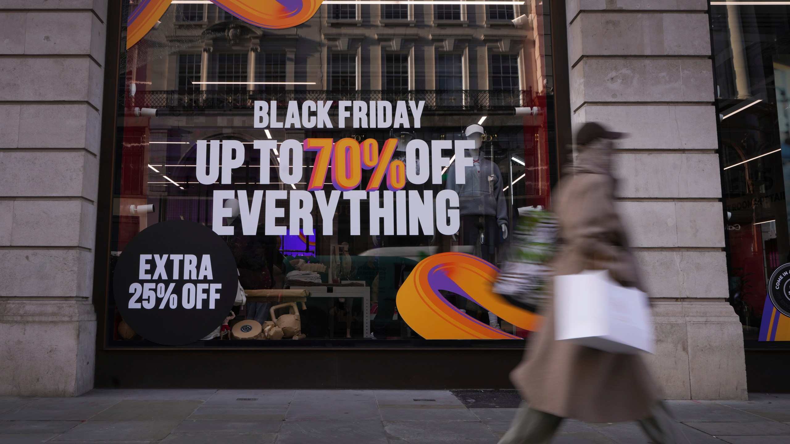 A shopper passes a store advertising a Black Friday Sale on Regent Street in London, Thursday, Nov. 28, 2024. (AP Photo/Kirsty Wigglesworth)