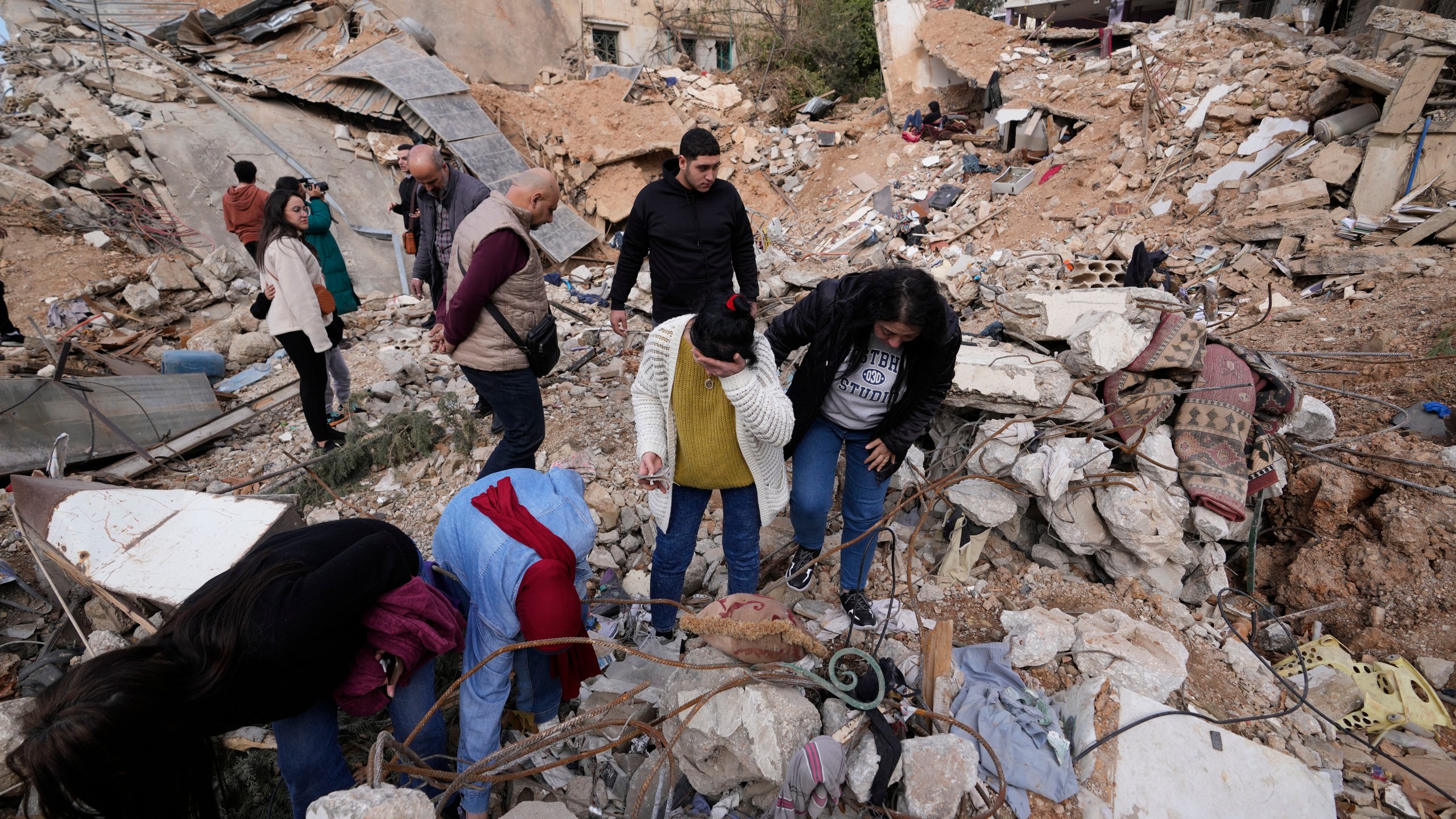 Displaced residents react as they stand in front of the rubble of their destroyed house in Baalbek, eastern Lebanon, Thursday, Nov. 28, 2024. (AP Photo/Hassan Ammar)