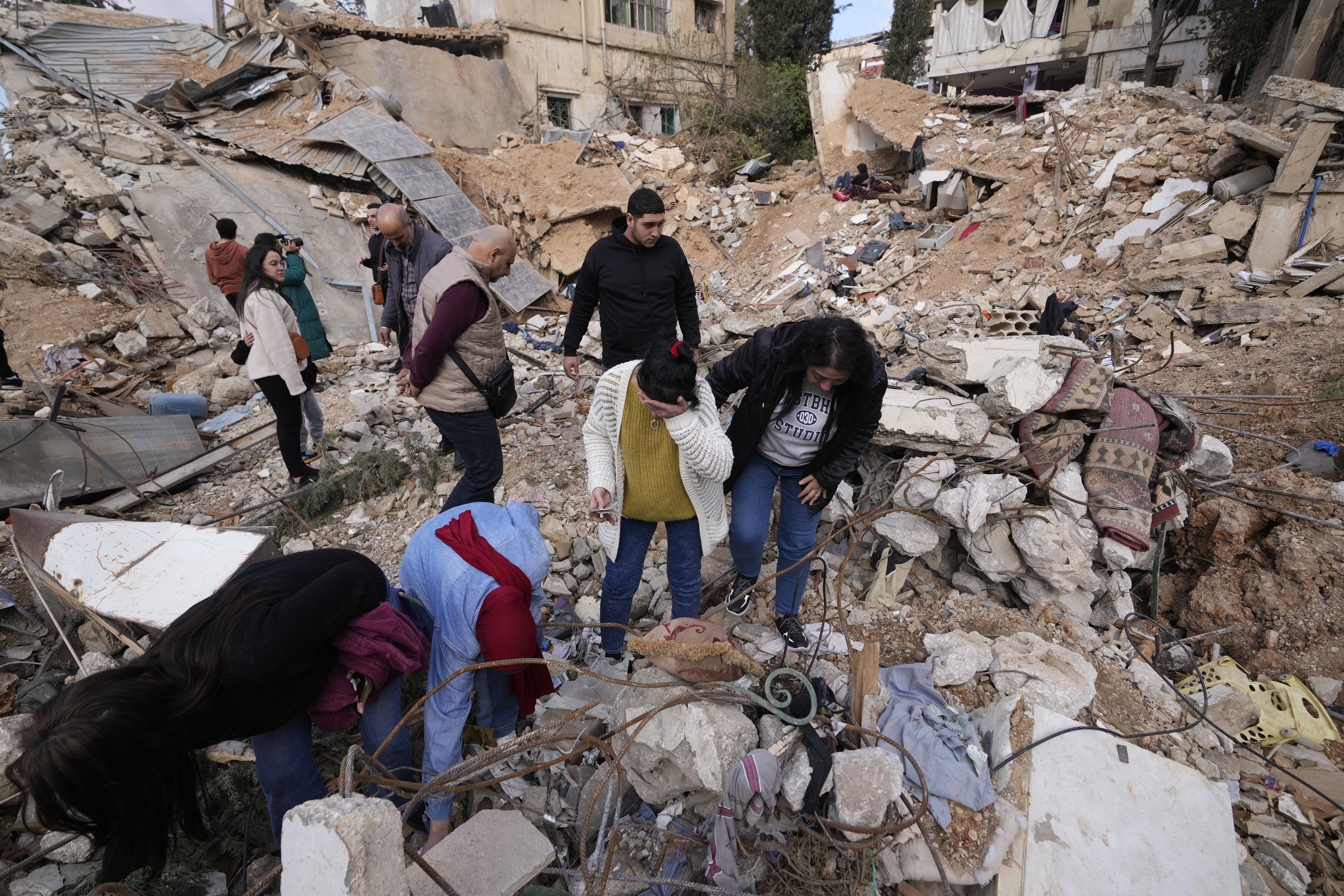 Displaced residents react as they stand in front of the rubble of their destroyed house in Baalbek, eastern Lebanon, Thursday, Nov. 28, 2024. (AP Photo/Hassan Ammar)