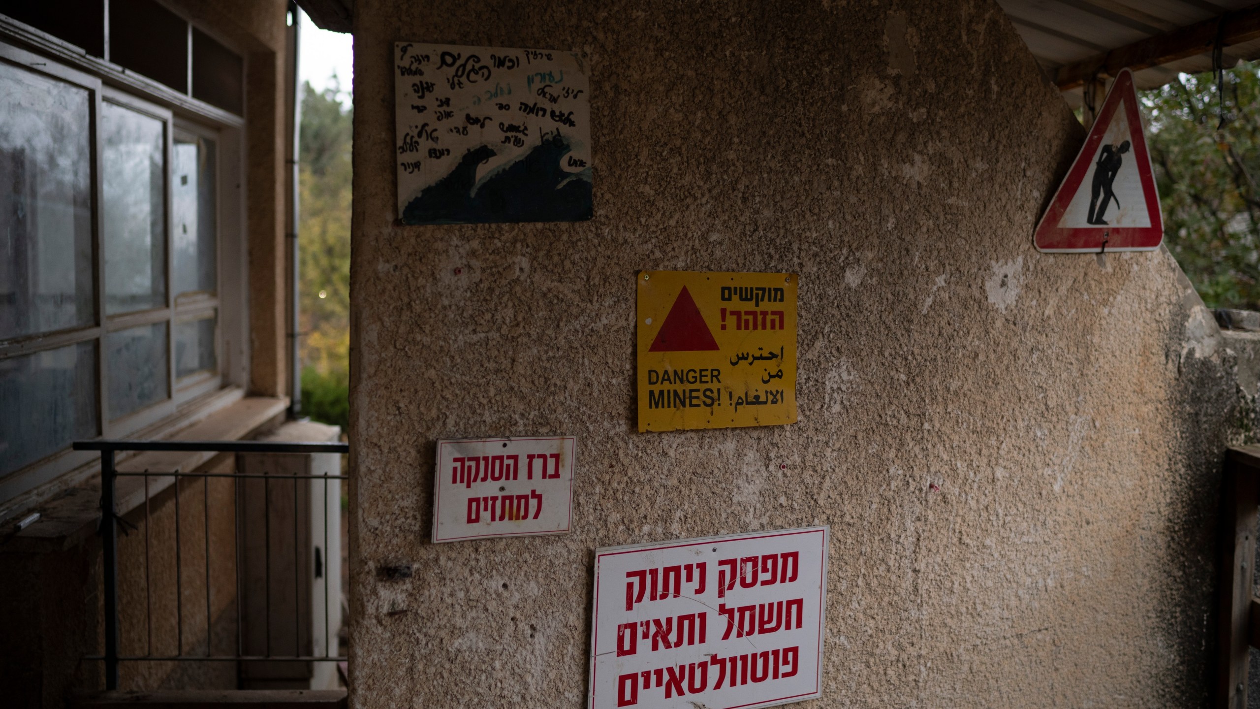 A sign alerting there danger of mines decorates a wall of the house for teenagers residents of the Kibbutz Malkiya, in the upper Galilee, northern Israel, Wednesday, Nov. 27, 2024. (AP Photo/Leo Correa)