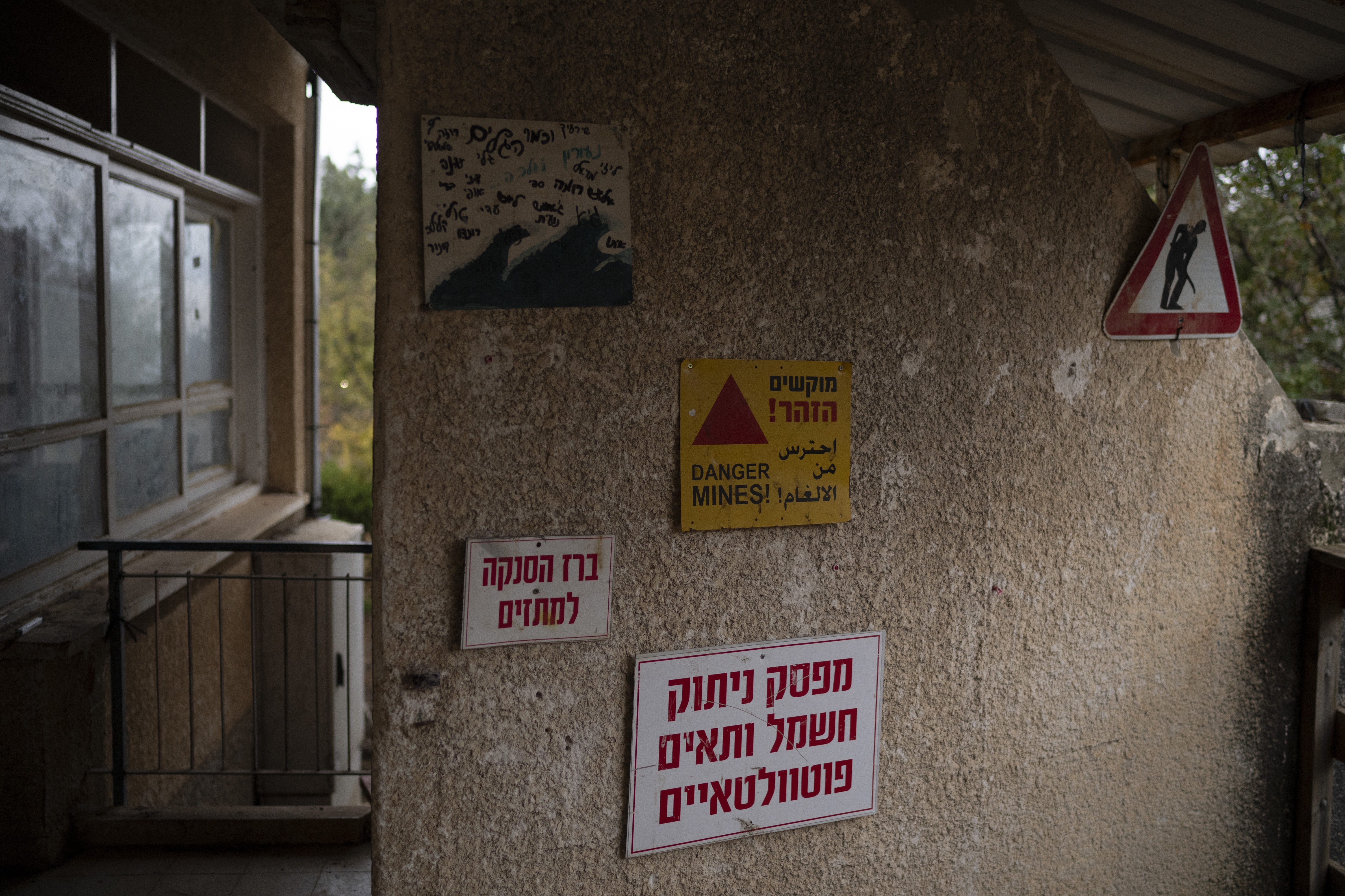 A sign alerting there danger of mines decorates a wall of the house for teenagers residents of the Kibbutz Malkiya, in the upper Galilee, northern Israel, Wednesday, Nov. 27, 2024. (AP Photo/Leo Correa)