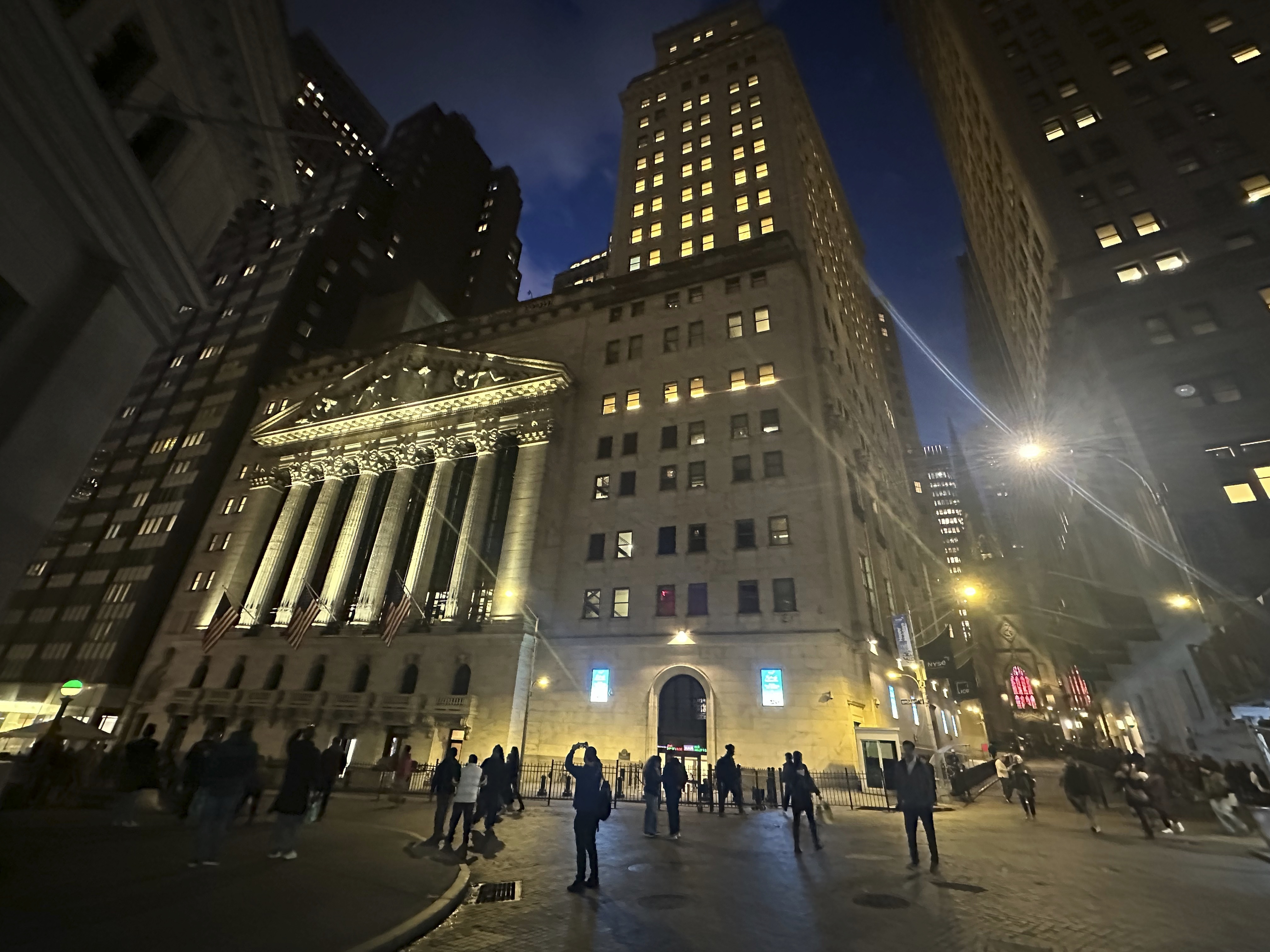 FILE - People walk past the New York Stock Exchange on Tuesday, Nov. 26 2024. (AP Photo/Peter Morgan, File)