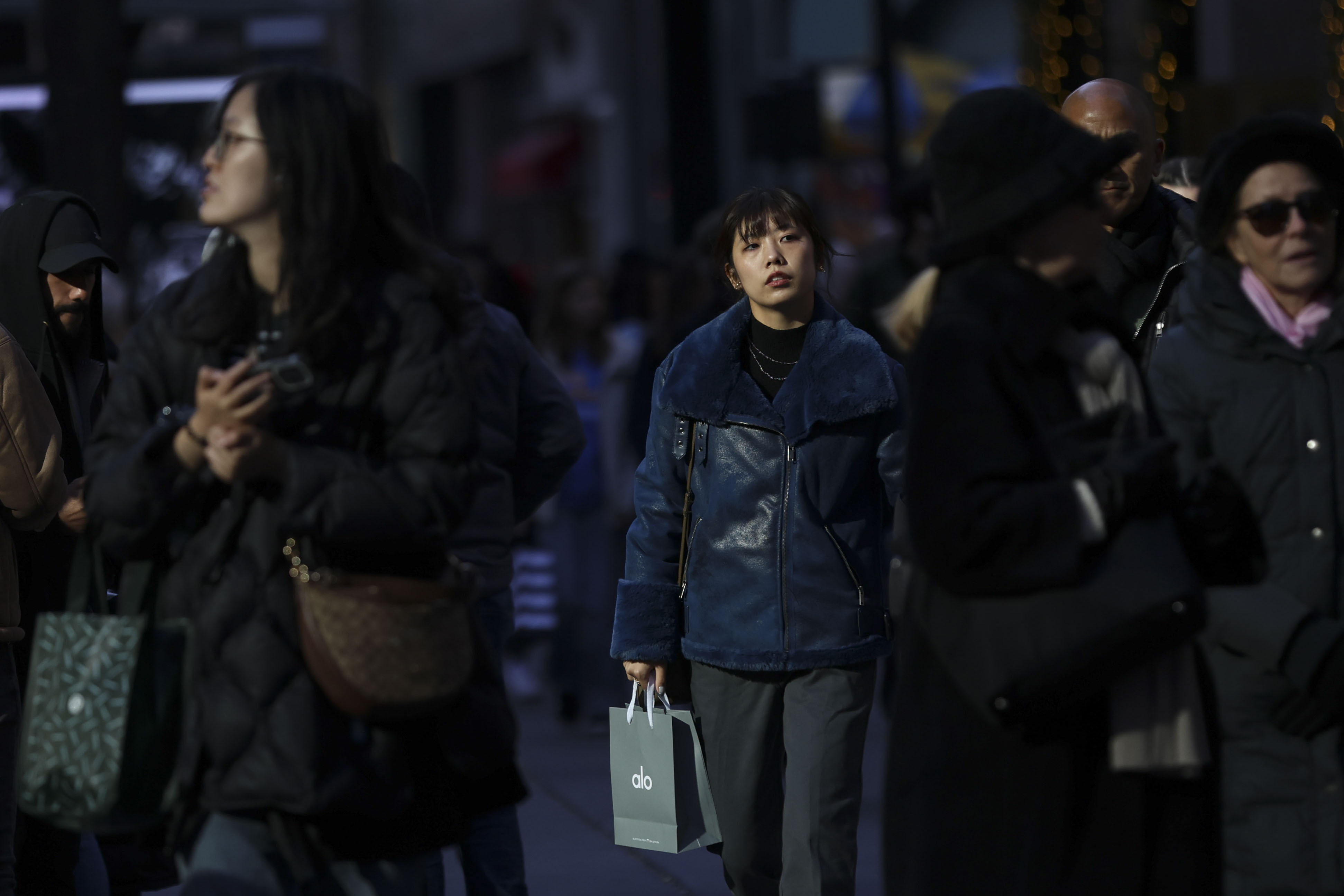 People carry shopping bags as they walk along Fifth Avenue, Friday, Nov. 29, 2024, in New York. (AP Photo/Heather Khalifa)