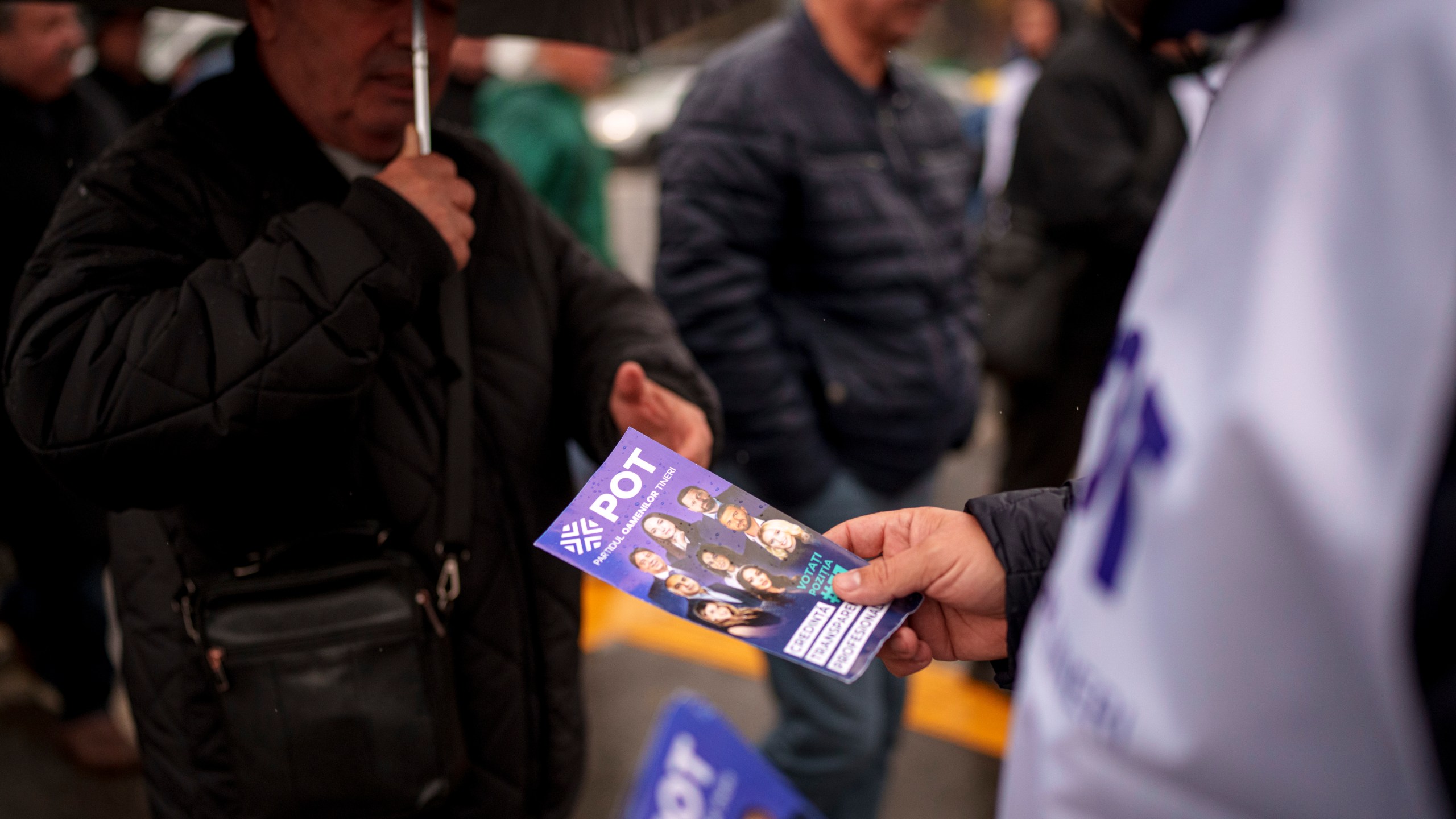 A man distributes leaflets of the Young People's Party or POT, which has backed Calin Georgescu, an independent candidate who won the first round of presidential elections, in Bucharest, Romania, Friday, Nov. 29, 2024. (AP Photo/Andreea Alexandru)