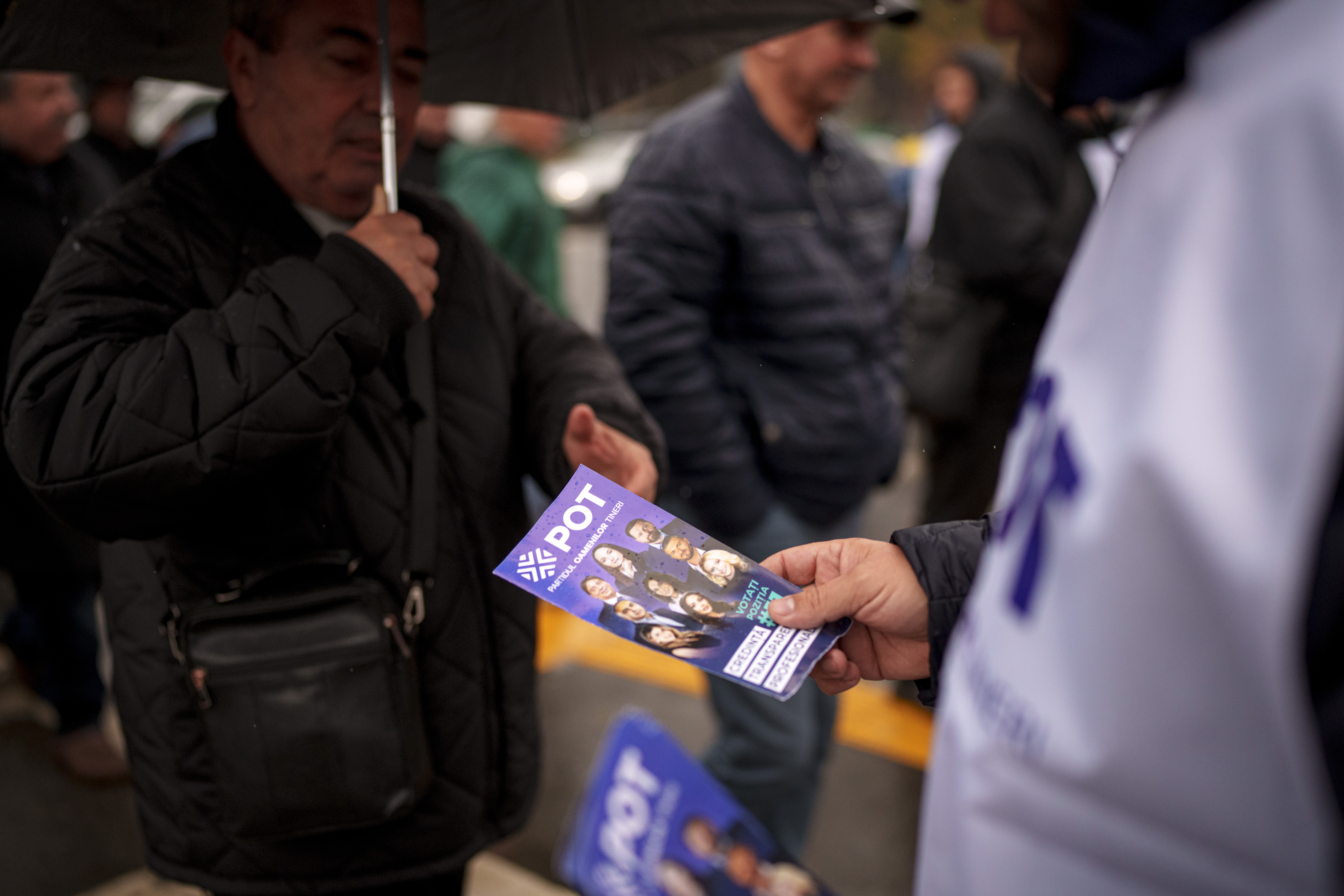 A man distributes leaflets of the Young People's Party or POT, which has backed Calin Georgescu, an independent candidate who won the first round of presidential elections, in Bucharest, Romania, Friday, Nov. 29, 2024. (AP Photo/Andreea Alexandru)