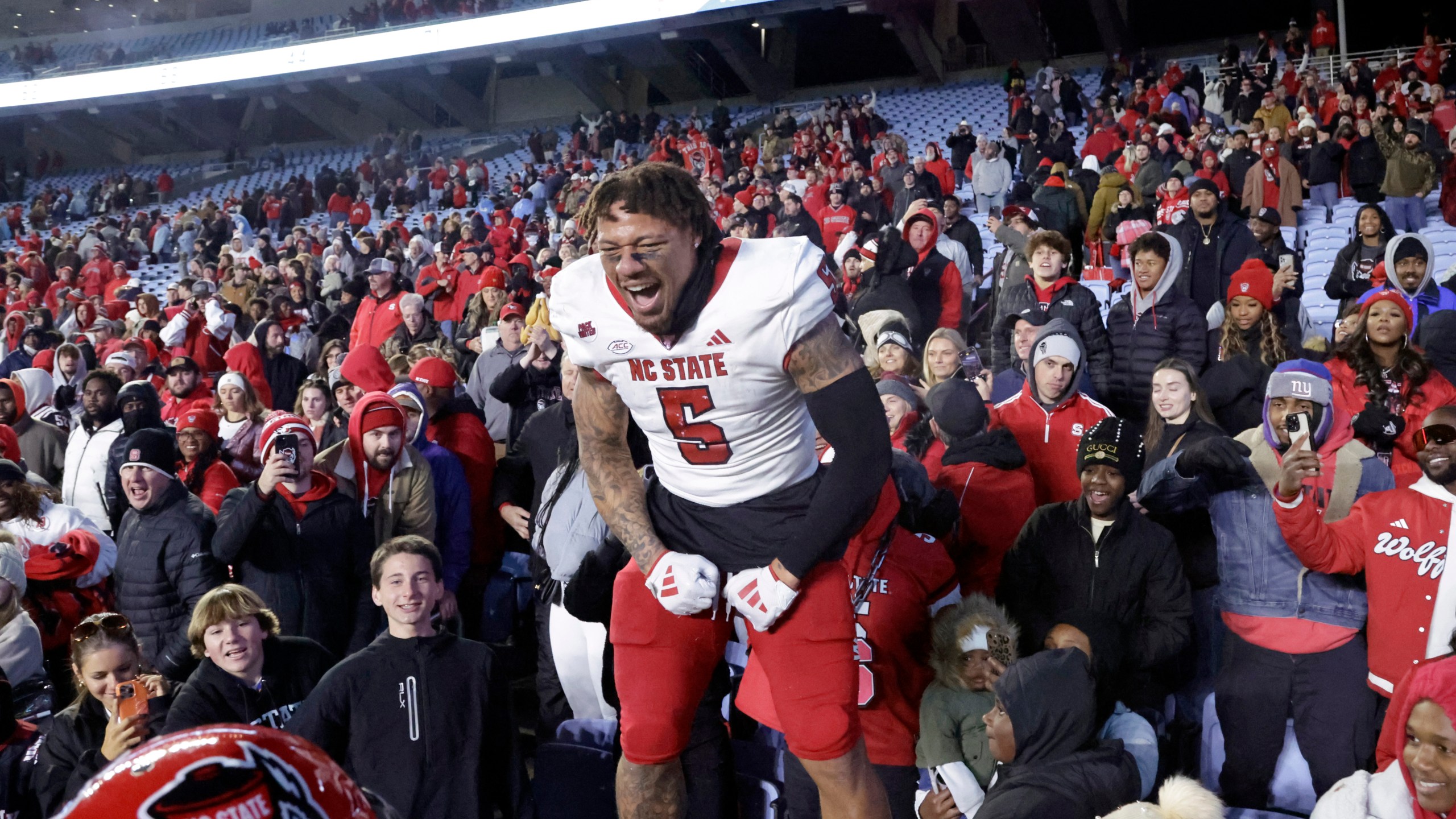 North Carolina State safety DK Kaufman (5) celebrates with the fans after defeating rival North Carolina in an NCAA college football game Saturday, Nov. 30, 2024, in Chapel Hill, N.C. (AP Photo/Chris Seward)