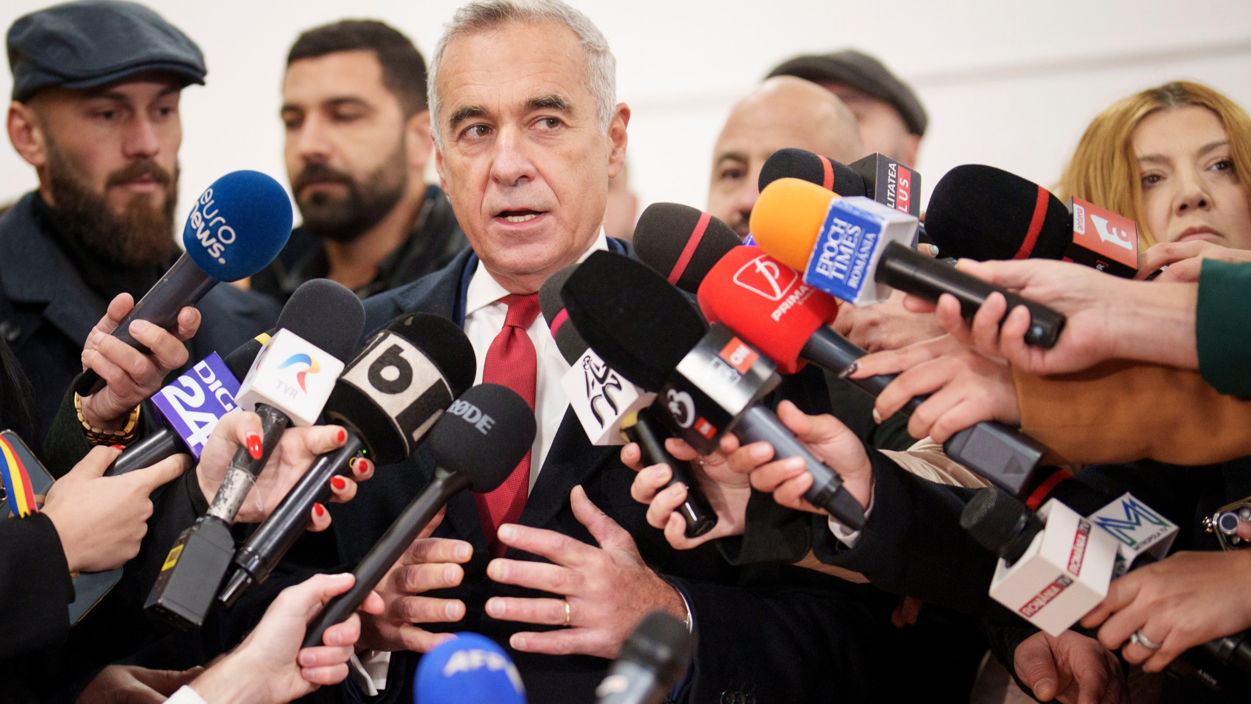 Calin Georgescu, an independent candidate for president who came first after the first round of presidential election, speaks to media after casting his vote in the country's parliamentary election in Mogosoaia, Romania, Sunday, Dec. 1, 2024. (AP Photo/Vadim Ghirda)