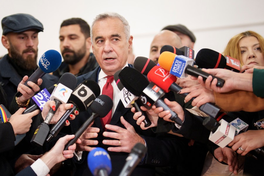 Calin Georgescu, an independent candidate for president who came first after the first round of presidential election, speaks to media after casting his vote in the country's parliamentary election in Mogosoaia, Romania, Sunday, Dec. 1, 2024. (AP Photo/Vadim Ghirda)