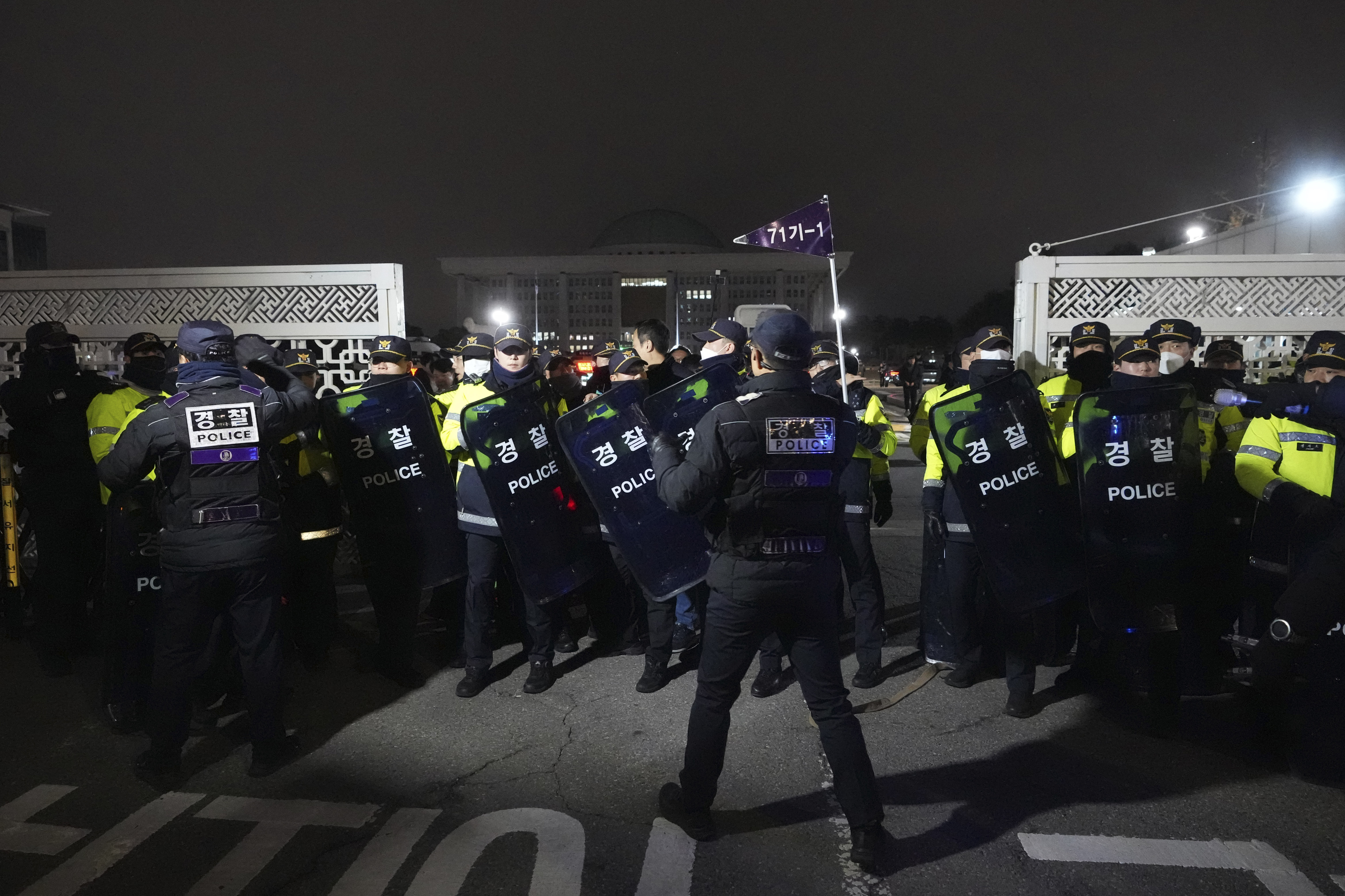 Police officers stand guard in front of the National Assembly in Seoul, South Korea, Tuesday, Dec. 3, 2024. (AP Photo/Lee Jin-man)