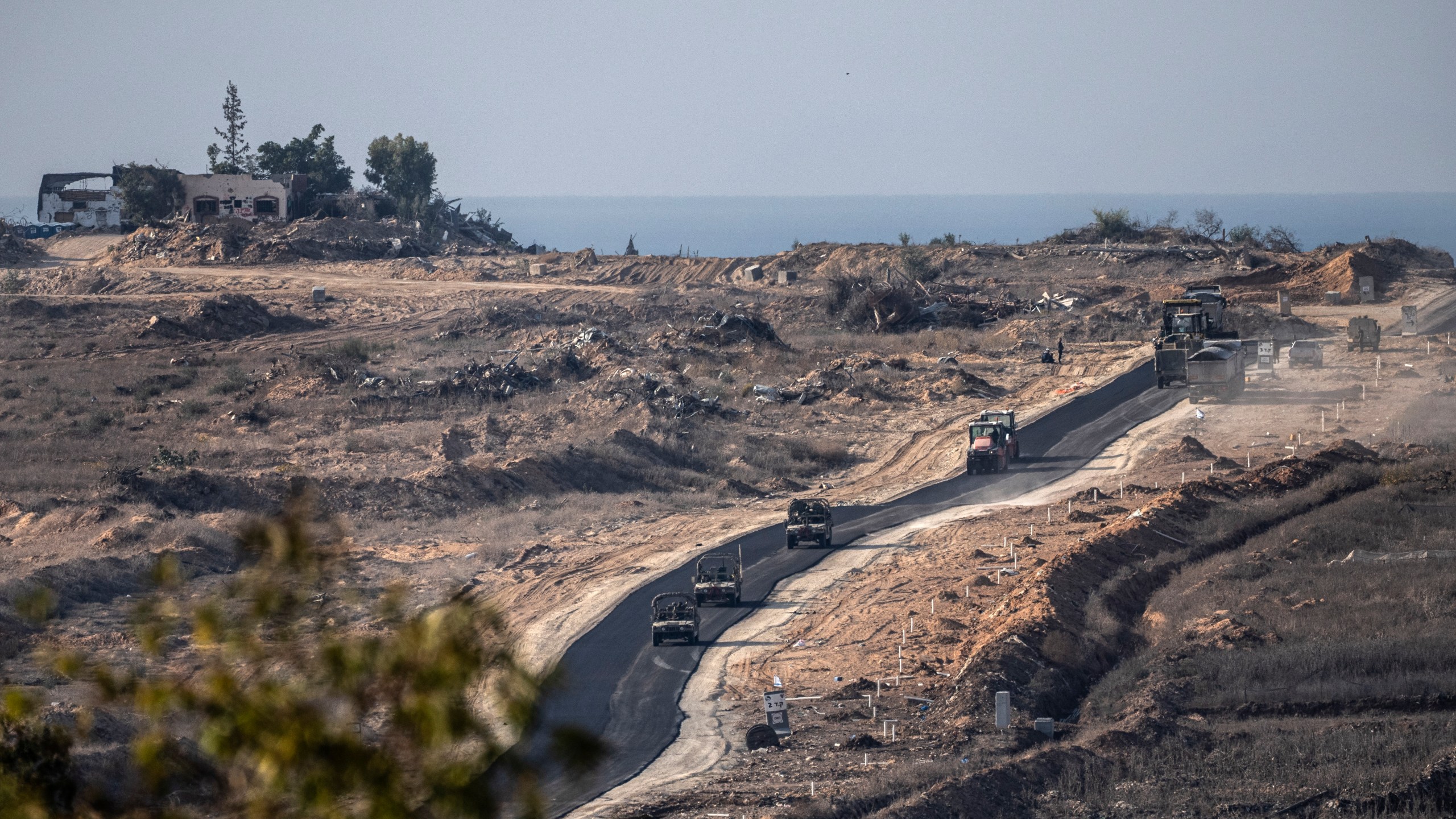 Israeli armoured vehicles move on in an area at the Israeli-Gaza border, seen from southern Israel, Tuesday, Dec. 3, 2024. (AP Photo/Tsafrir Abayov)