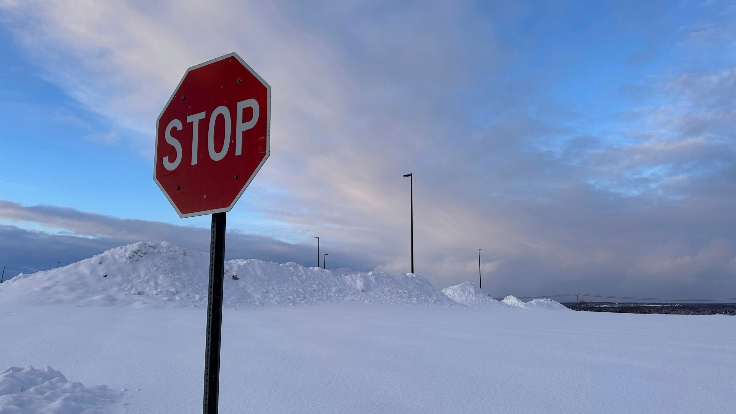 Snow is piled at a parking lot in Lowville, N.Y., on Tuesday, Dec. 3, 2024. (AP Photo/Cara Anna)