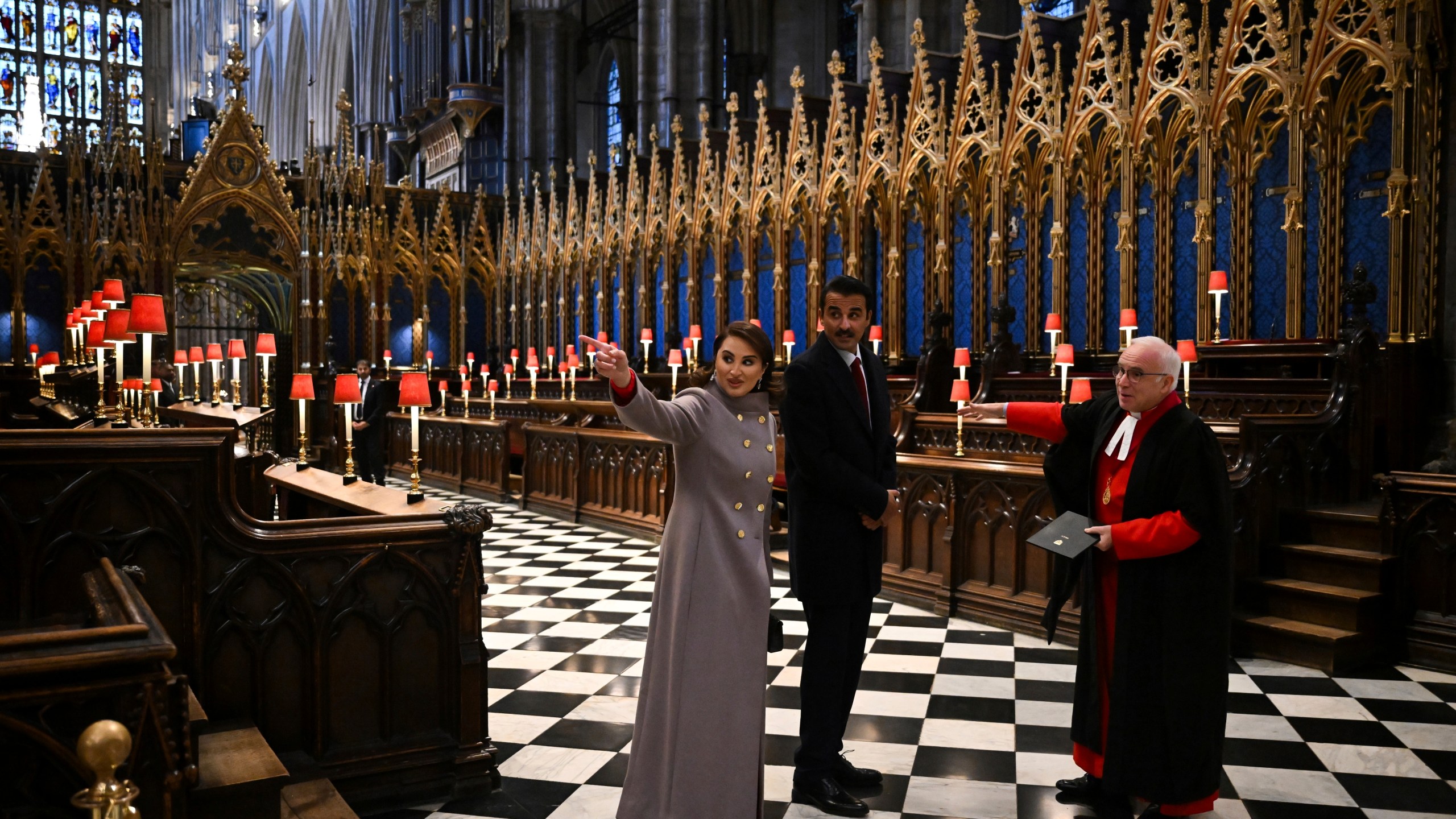 Qatar's Emir Sheikh Tamim bin Hamad al-Thani, center, and his wife Sheikha Jawaher bint Hamad bin Suhaim al-Thani, left, react during a visit to Westminster Abbey with Westminster Dean David Hoyle, in London, Tuesday, Dec. 3, 2024, on the first day of their two-day State Visit to Britain. ( Justin Tallis/Pool photo via AP)