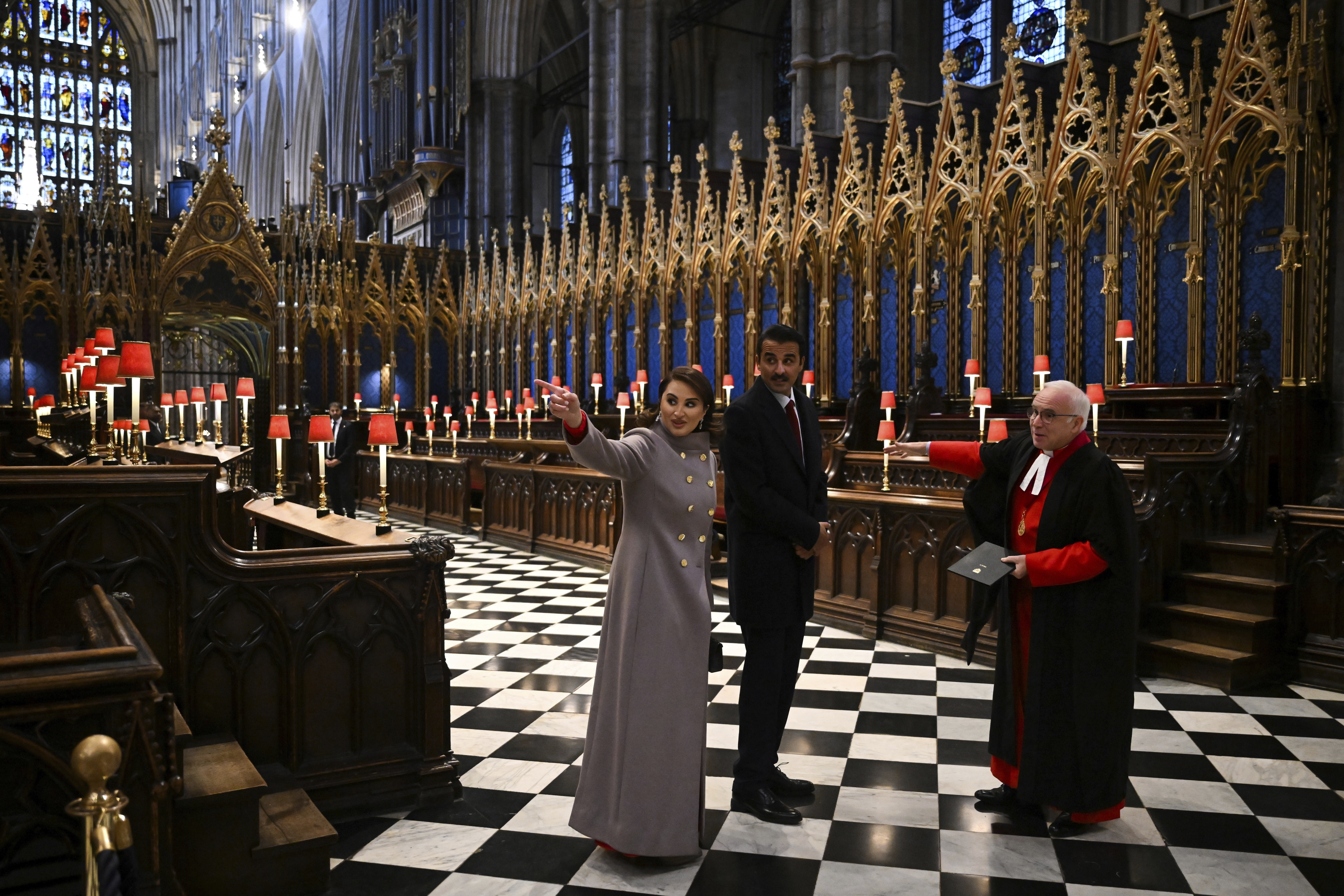 Qatar's Emir Sheikh Tamim bin Hamad al-Thani, center, and his wife Sheikha Jawaher bint Hamad bin Suhaim al-Thani, left, react during a visit to Westminster Abbey with Westminster Dean David Hoyle, in London, Tuesday, Dec. 3, 2024, on the first day of their two-day State Visit to Britain. ( Justin Tallis/Pool photo via AP)