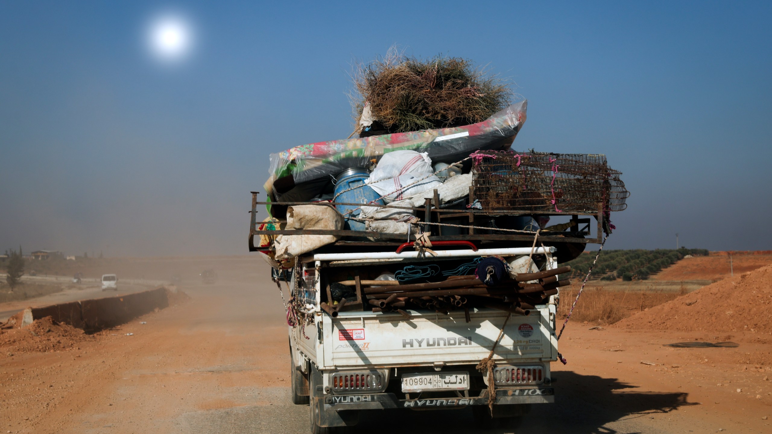 Civilians carrying their belongings leave the area as Syrian opposition fighters confront government troops, in the village of Suran, north of Hama, Syria, Tuesday Dec. 3, 2024.(AP Photo/Ghaith Alsayed)