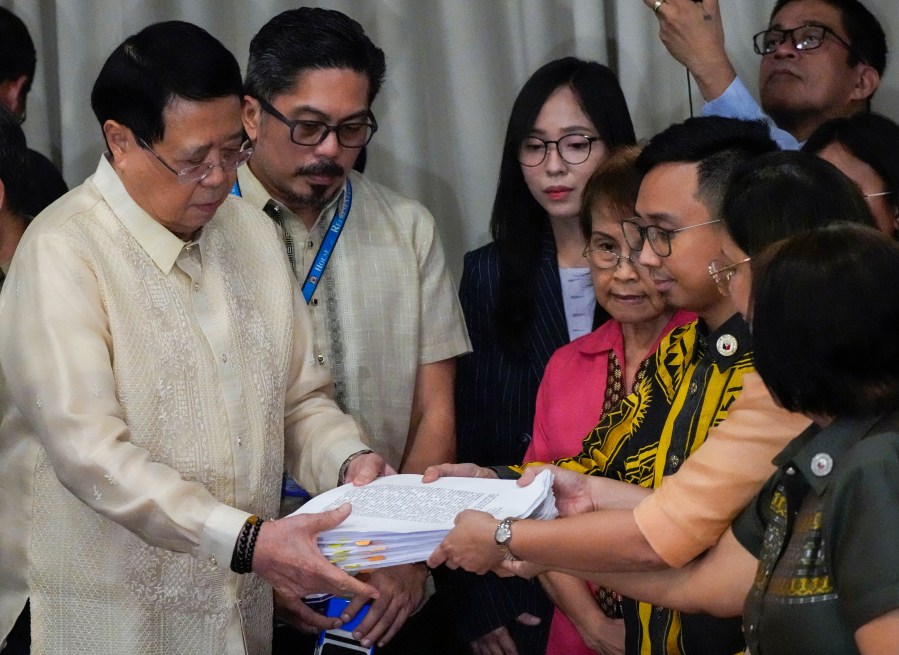 House Secretary General, Reginald Velasco, left, receives a second impeachment complaint filed against Philippine Vice President Sara Duterte on Wednesday Dec. 4, 2024 at the House of Representatives in Quezon City, Philippines. (AP Photo/Aaron Favila)