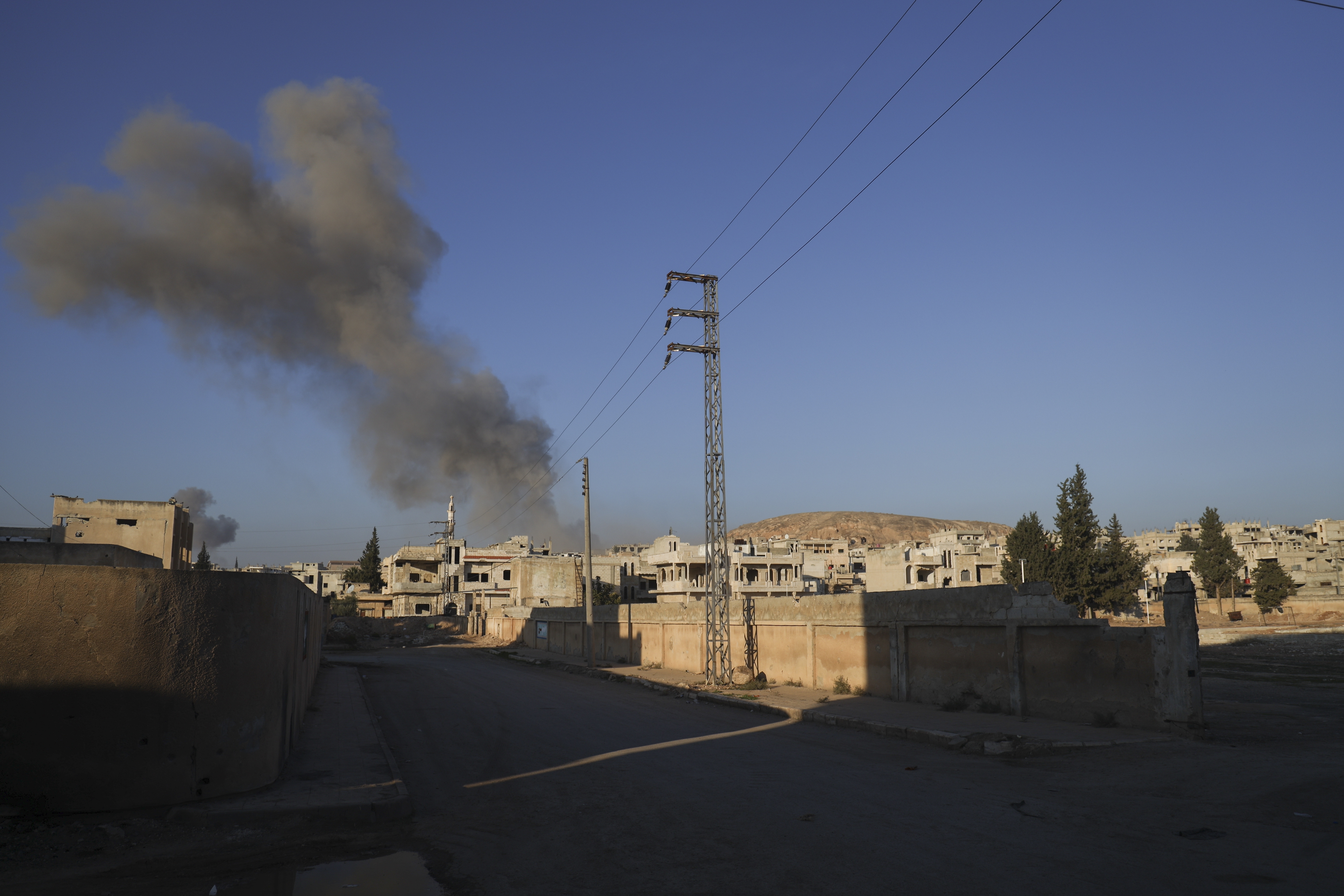 Smoke from an airstrike by government forces billows in the sky over the town of Khan Sheikhoun, south of Idlib, Syria, Tuesday, Dec. 3, 2024. (AP Photo/Omar Albam)