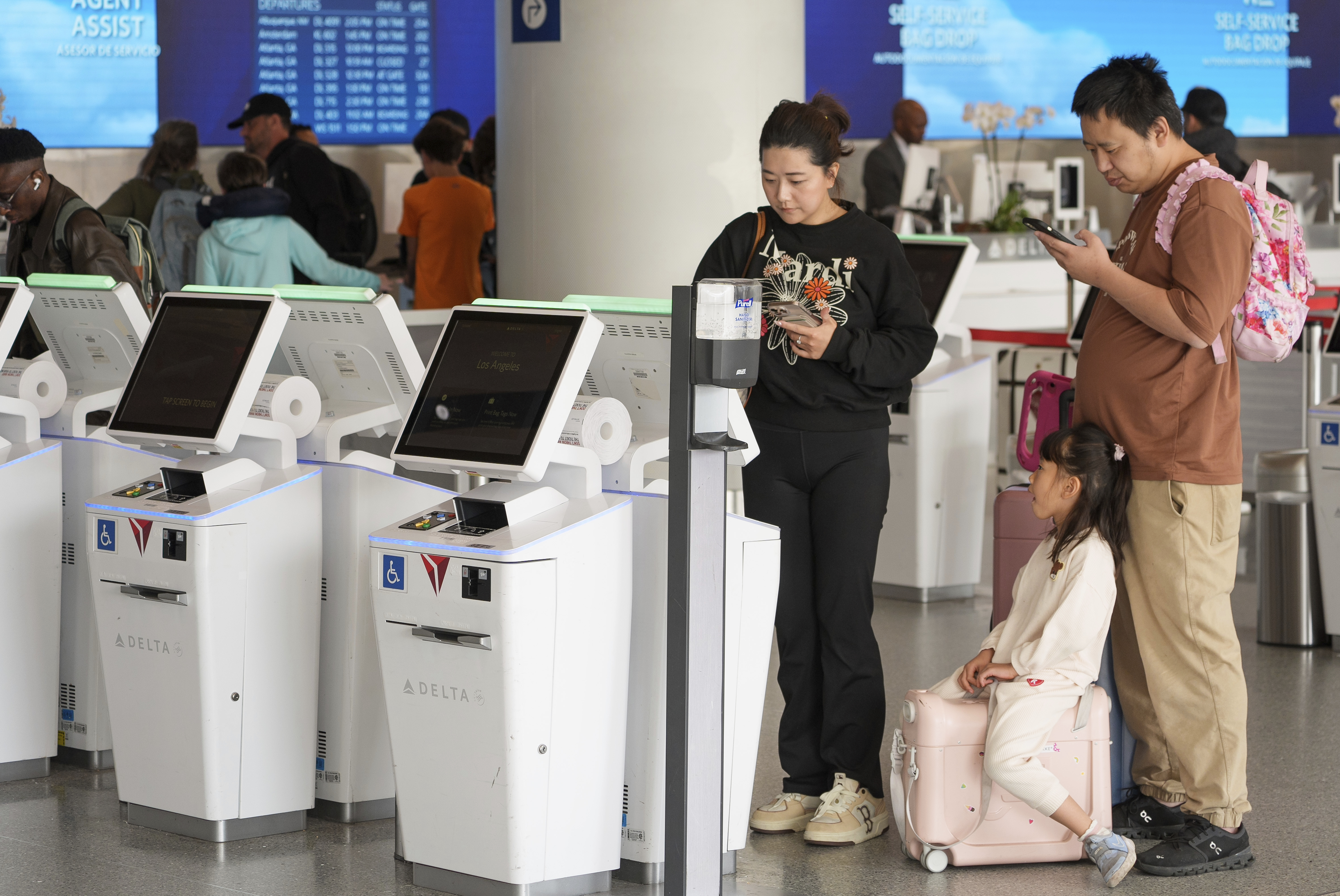 Travelers self-check at Delta Airlines counter at Los Angeles International Airport in Los Angeles, Wednesday, Nov. 27, 2024. (AP Photo/Damian Dovarganes)