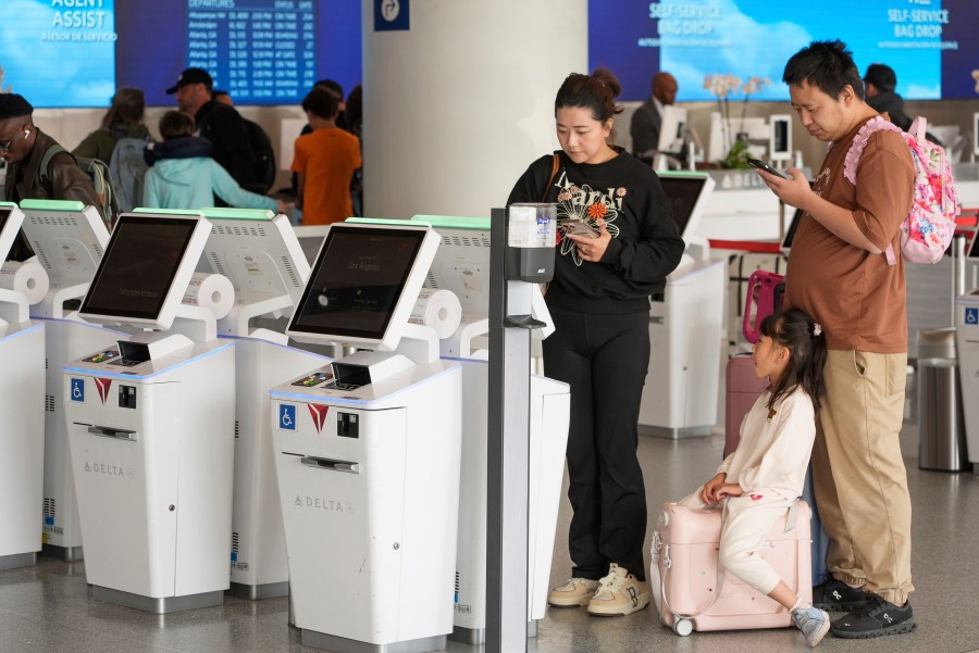 Travelers self-check at Delta Airlines counter at Los Angeles International Airport in Los Angeles, Wednesday, Nov. 27, 2024. (AP Photo/Damian Dovarganes)