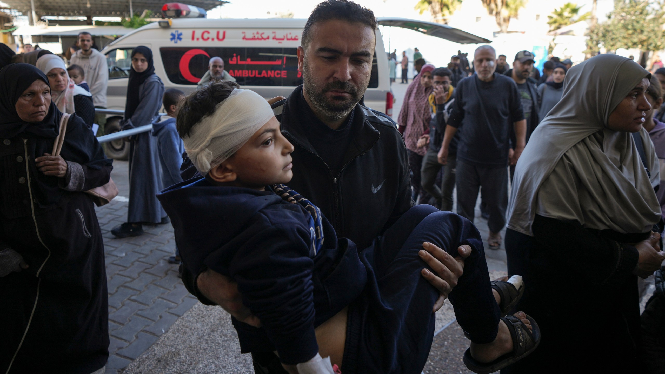 A Palestinian man carries a wounded child, following an Israeli bombardment in Nuseirat, central Gaza, as they arrive at the Al-Aqsa Martyrs hospital in Deir al-Balah, Gaza Strip Wednesday, Dec. 4, 2024. (AP Photo/Abdel Kareem Hana)