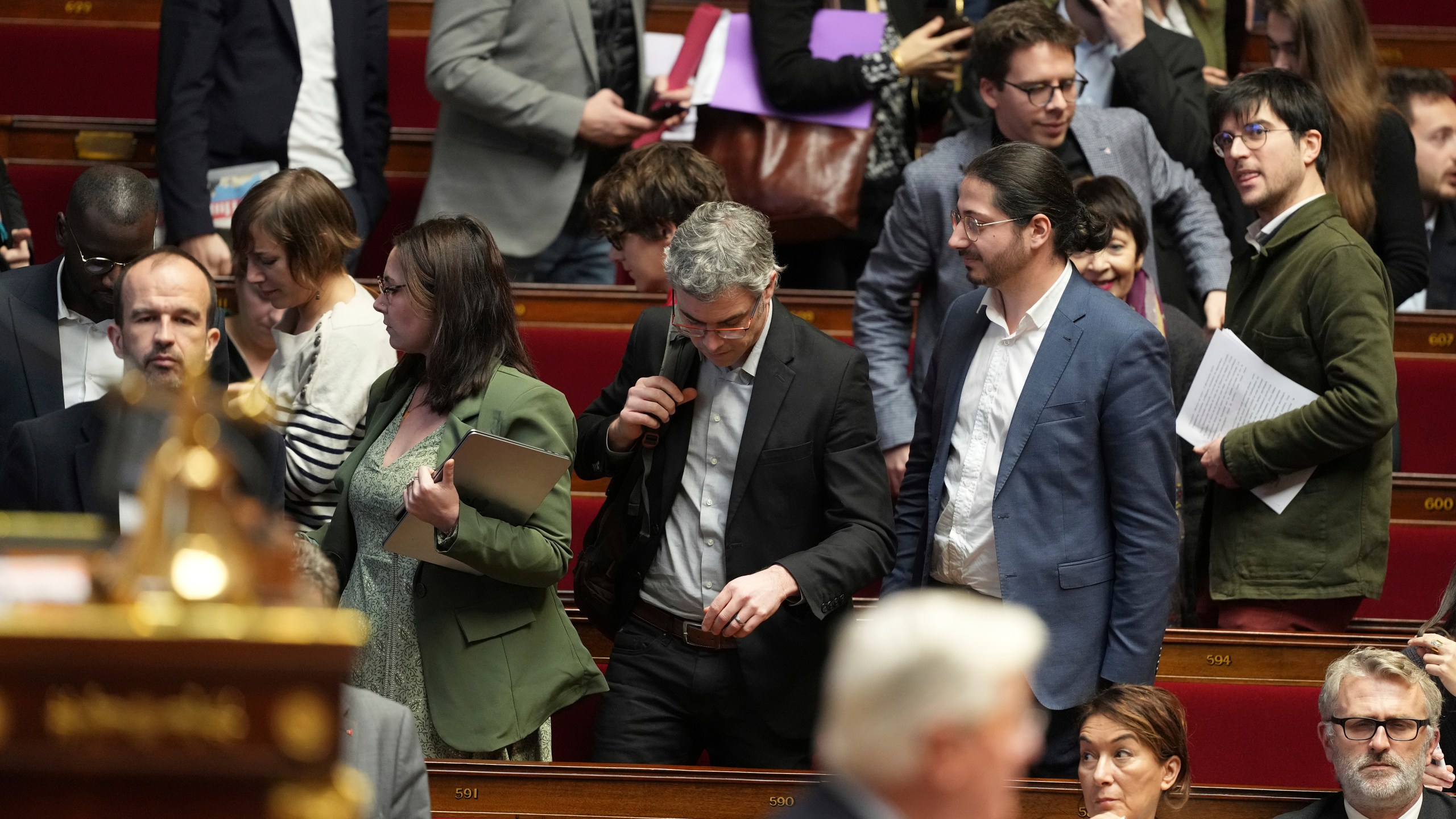 Leftist parliament members leave as French Prime Minister Michel Barnier delivers his speech at the National Assembly while France's minority government may be on its last legs as opposition lawmakers moved this week toward a no-confidence vote, Monday, Dec. 2, 2024 in Paris. (AP Photo/Michel Euler)