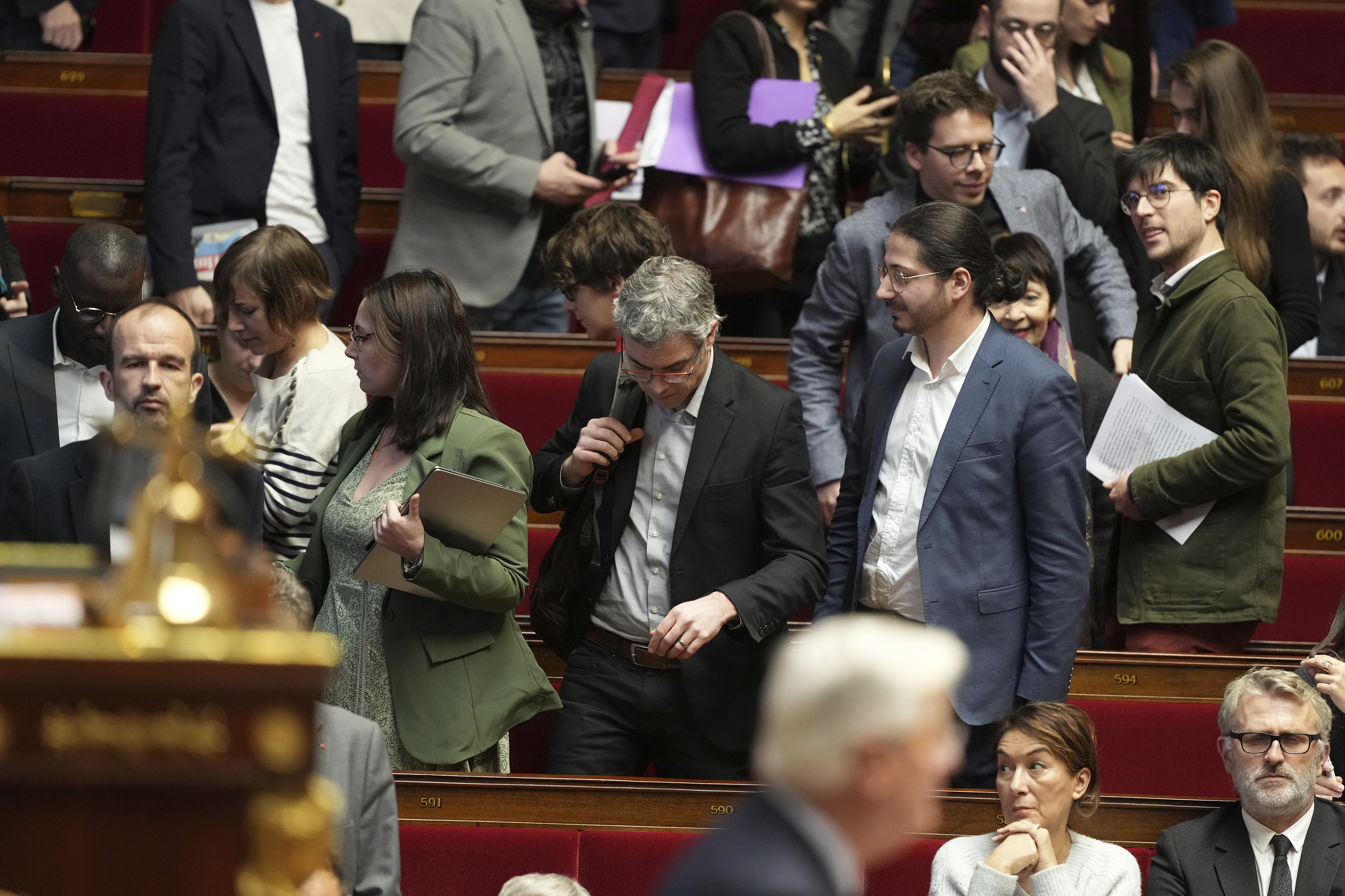 Leftist parliament members leave as French Prime Minister Michel Barnier delivers his speech at the National Assembly while France's minority government may be on its last legs as opposition lawmakers moved this week toward a no-confidence vote, Monday, Dec. 2, 2024 in Paris. (AP Photo/Michel Euler)