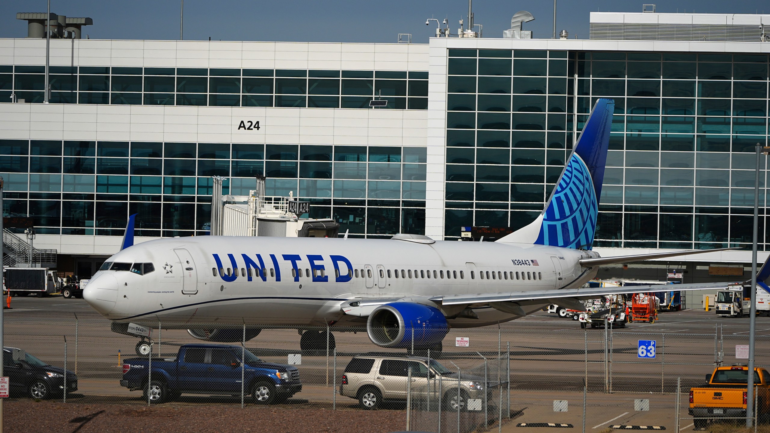 As traffic passes by in the foreground, a United Airlines jetliner turns on the tarmac to leave the A Concourse and head to a runway at Denver International Airport Tuesday, Nov. 26, 2024, in Denver. (AP Photo/David Zalubowski)