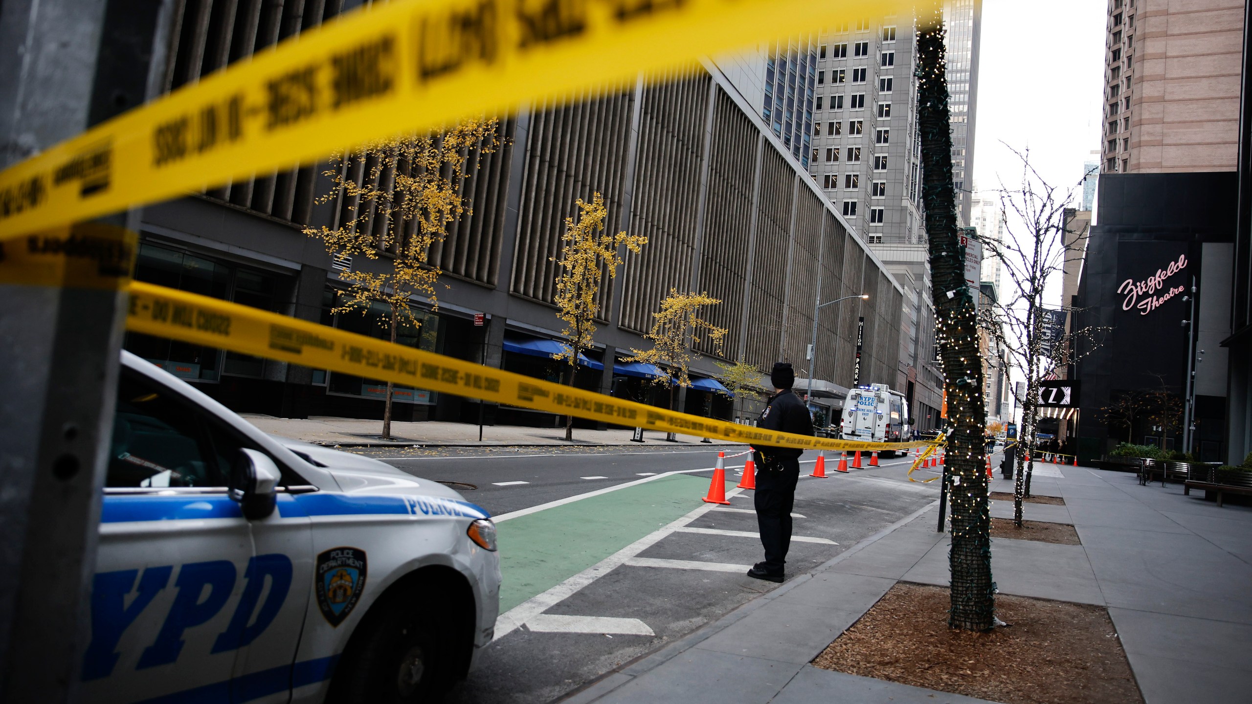 A New York police officer stands on 54th Street outside the Hilton Hotel in midtown Manhattan where Brian Thompson, the CEO of UnitedHealthcare, was fatally shot Wednesday, Dec. 4, 2024, in New York. (AP Photo/Stefan Jeremiah)