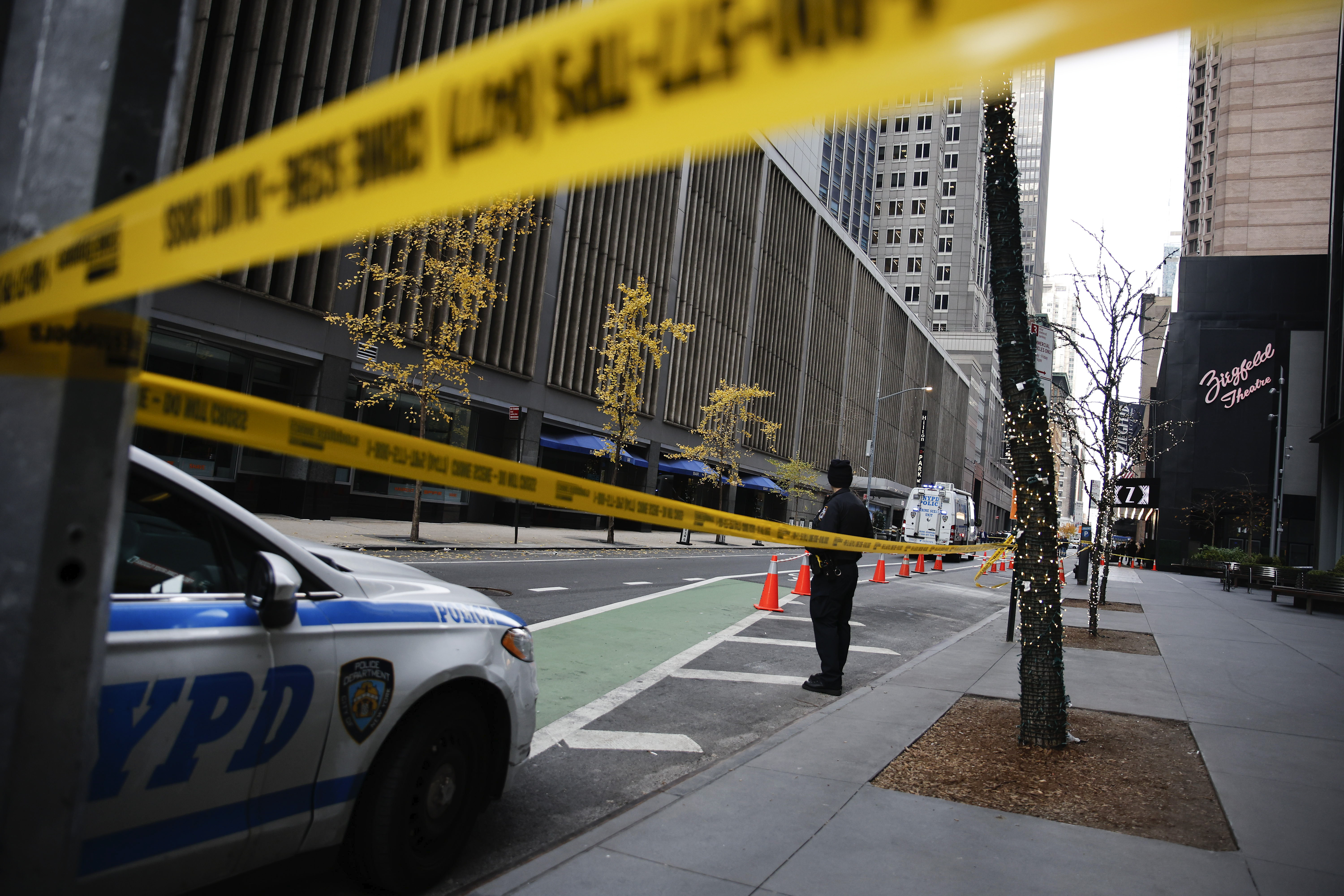 A New York police officer stands on 54th Street outside the Hilton Hotel in midtown Manhattan where Brian Thompson, the CEO of UnitedHealthcare, was fatally shot Wednesday, Dec. 4, 2024, in New York. (AP Photo/Stefan Jeremiah)