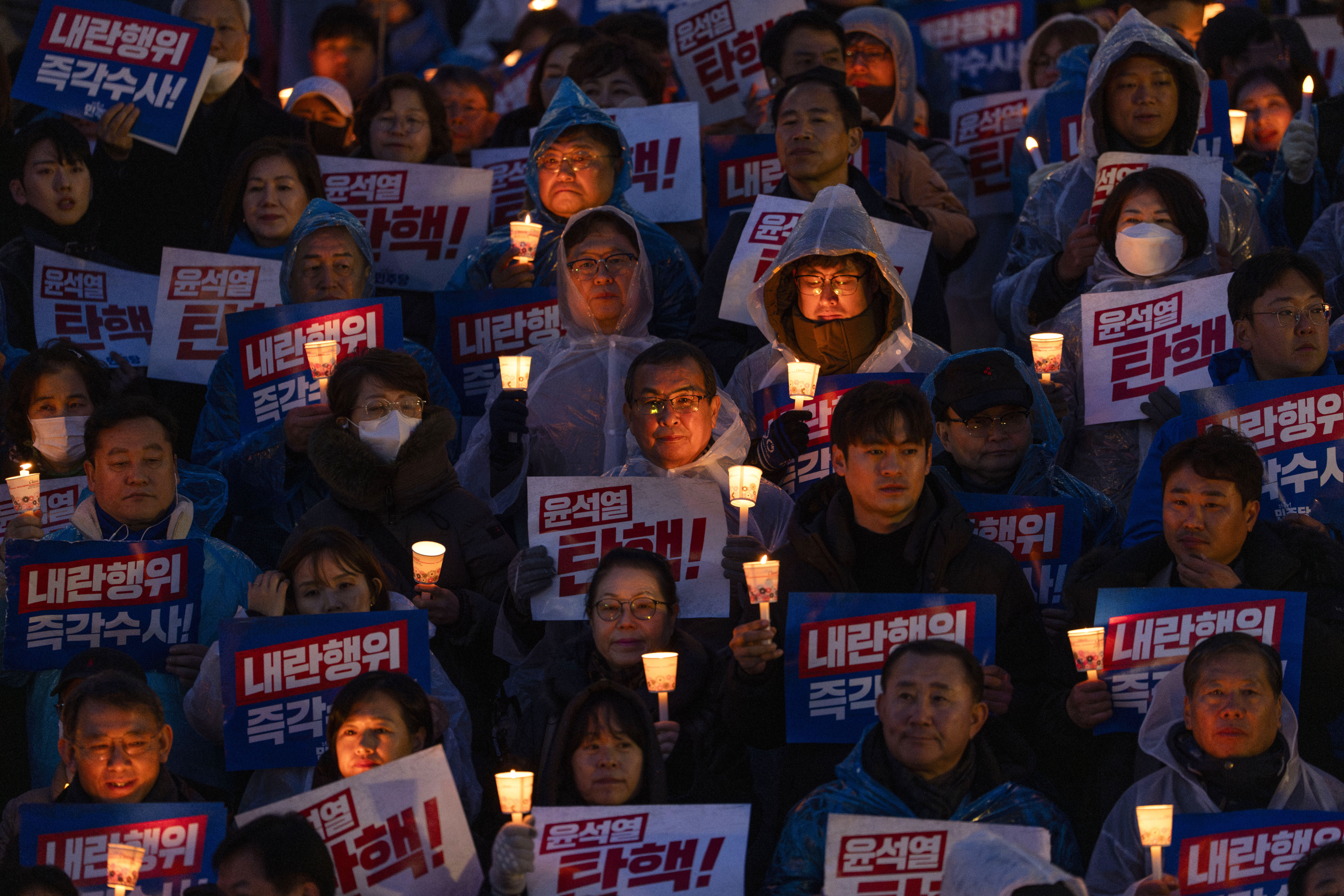 Protesters hold up banners that reads "Impeach Yoon Suk Yeol " at a candlelight vigil against South Korean President Yoon Suk Yeol in Seoul, South Korea, Thursday, Dec. 5, 2024 (AP Photo/Ng Han Guan)