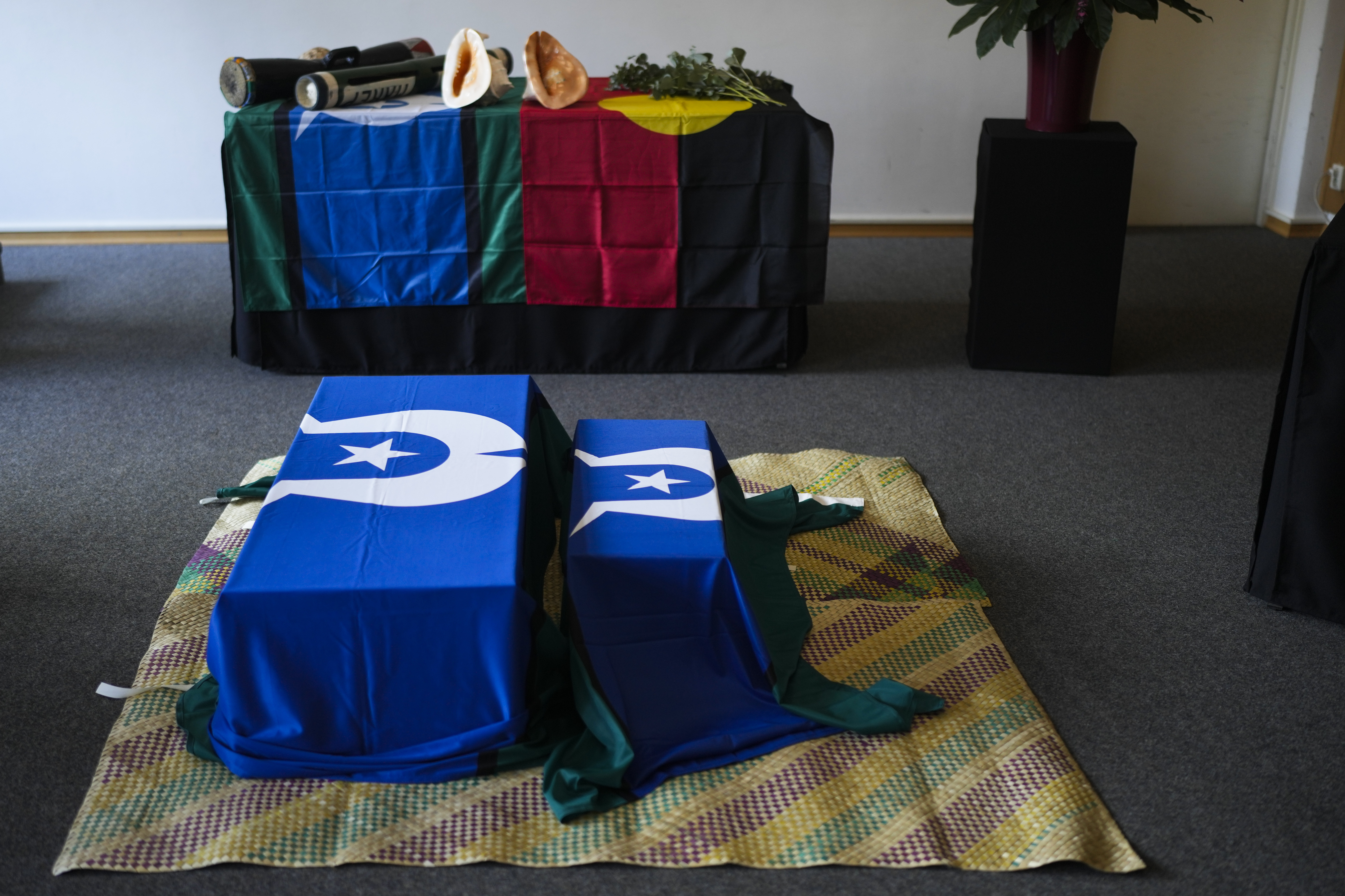 Two coffins lie on a traditional mat during a ceremony for the return of Aboriginal Australians' ancestors to their relatives and communities at the Ethnological Museum in Berlin, Germany, Thursday, Dec. 5, 2024. (AP Photo/Markus Schreiber)