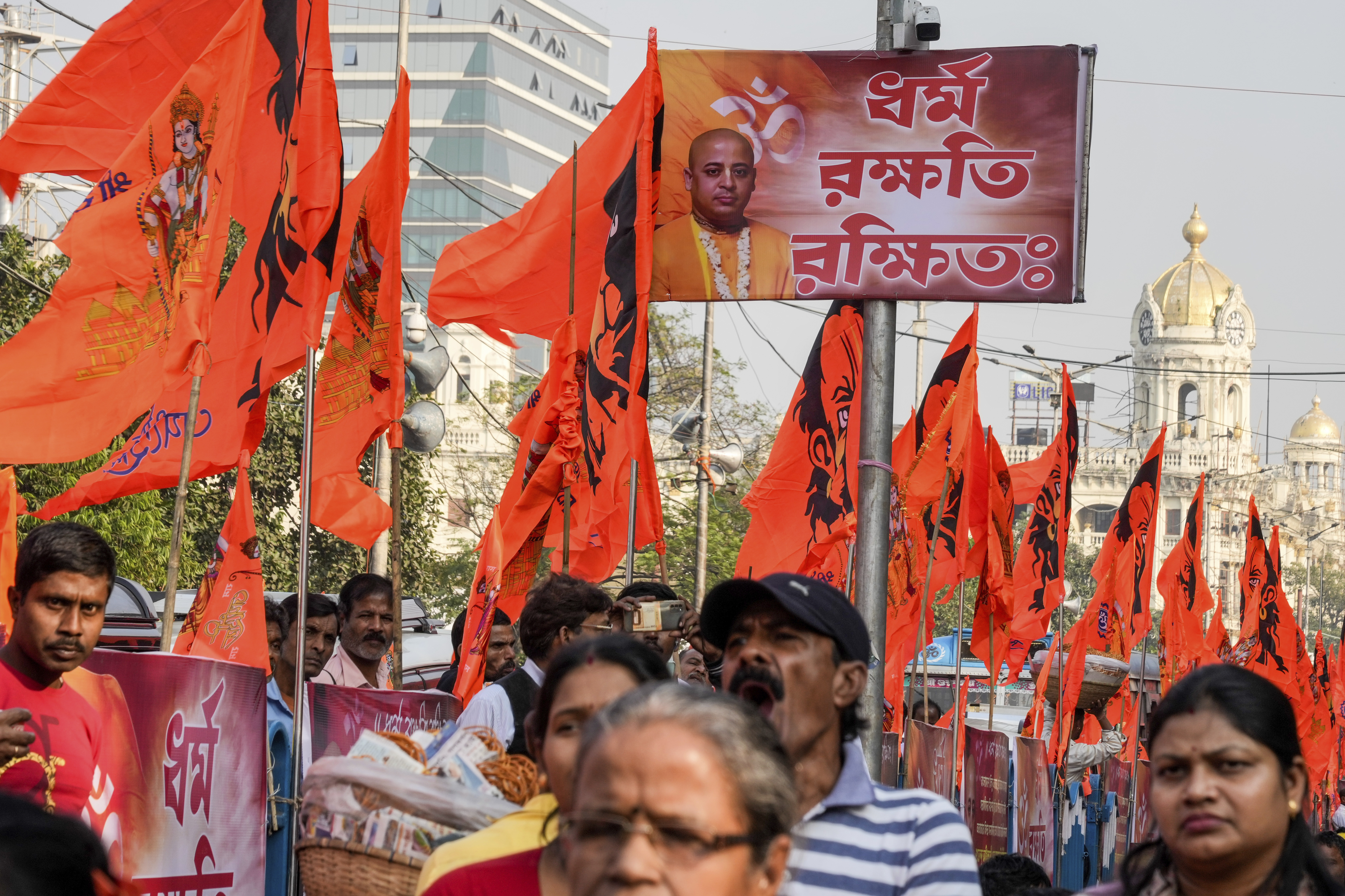 A poster of arrested prominent Hindu leader Krishna Das Prabhu displayed on a lamp post amidst rows of Hindu religious flags during a protest rally condemning the recent arrest of Das and the alleged attacks on Hindus in Bangladesh, in Kolkata, India, Thursday, Dec. 5, 2024. (AP Photo/Bikas Das)