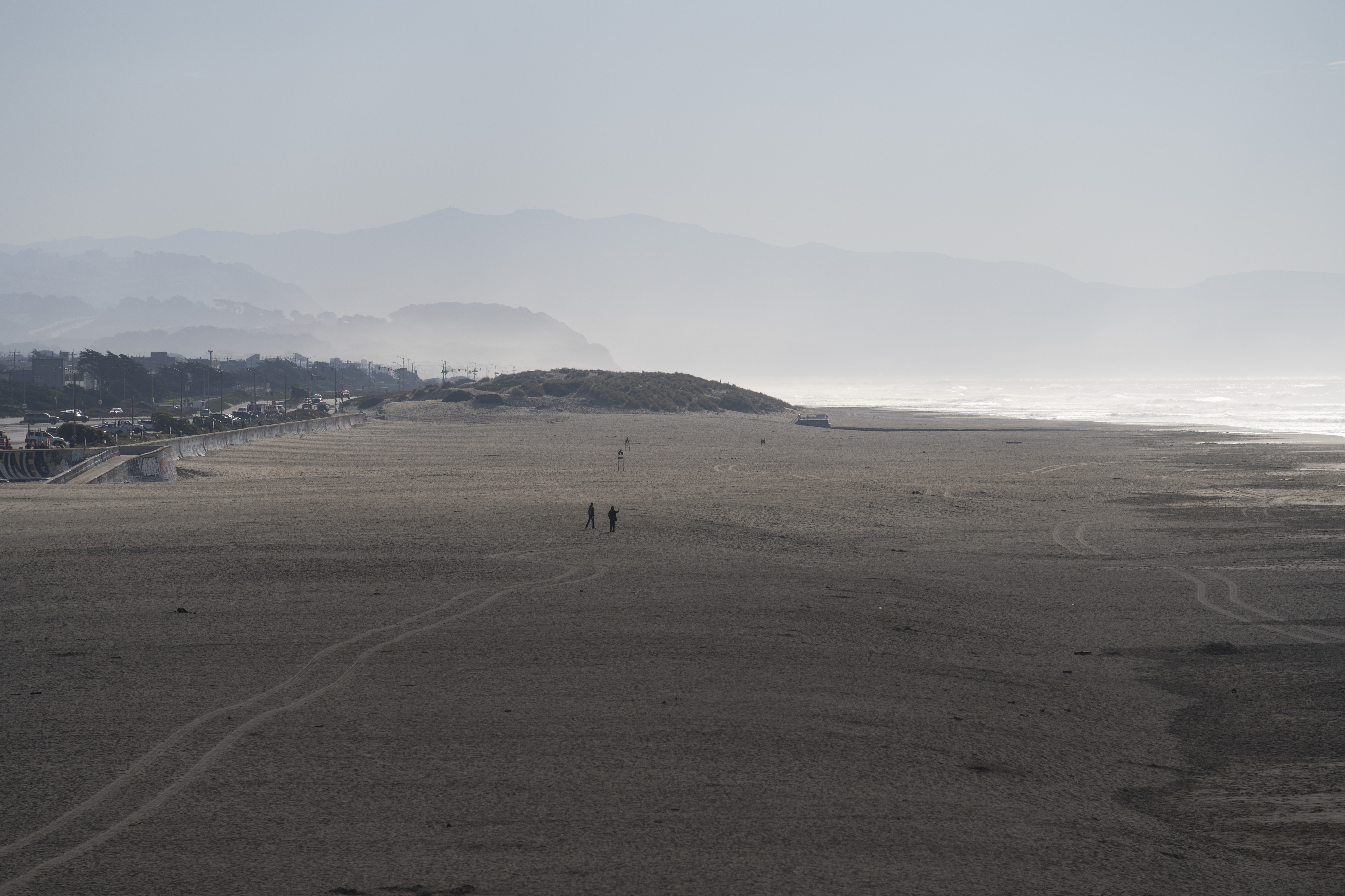 People walk onto the sand at Ocean Beach in San Francisco during a tsunami warning on Thursday, Dec. 5, 2024. (AP Photo/Emily Steinberger)