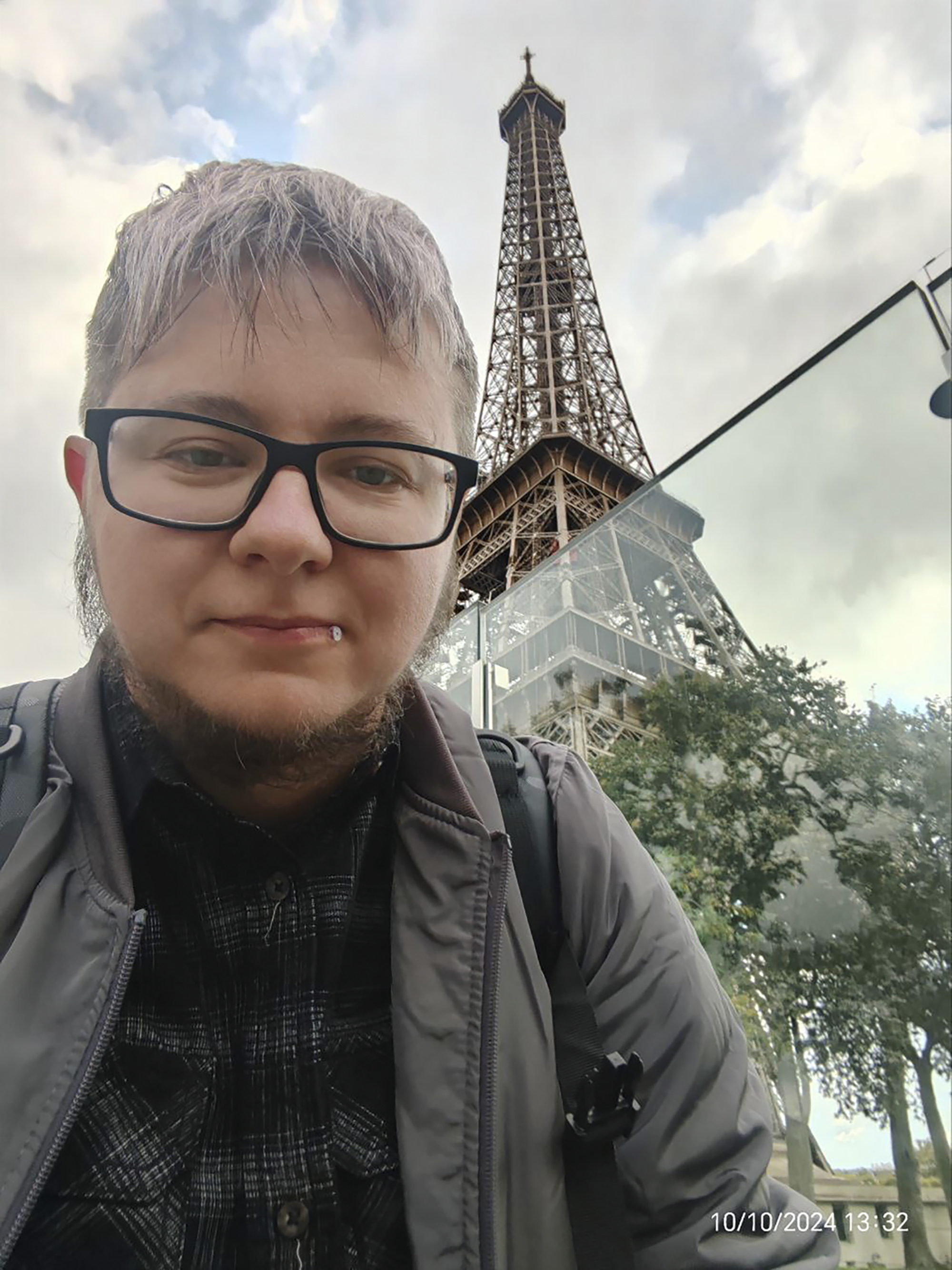 Marat, a transgender man who fled Belarus and wanted to be identified only by his first name over concerns for his safety, poses in front of the Eiffel Tower in Paris on Oct. 10, 2024. (Marat via AP)