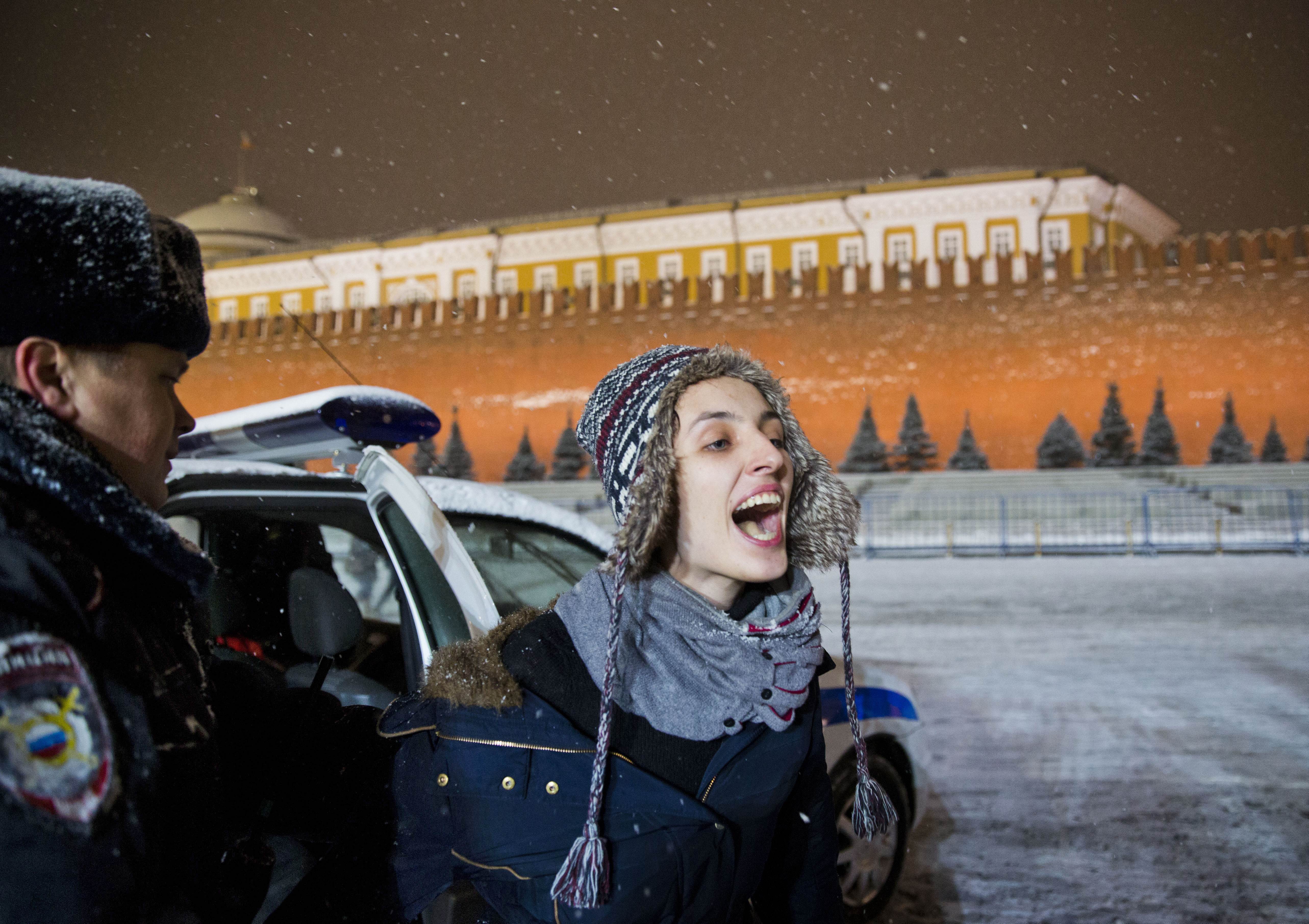 FILE - A police officer detains a gay rights activist in Red Square in Moscow on Feb. 7, 2014. (AP Photo/Evgeny Feldman, File)