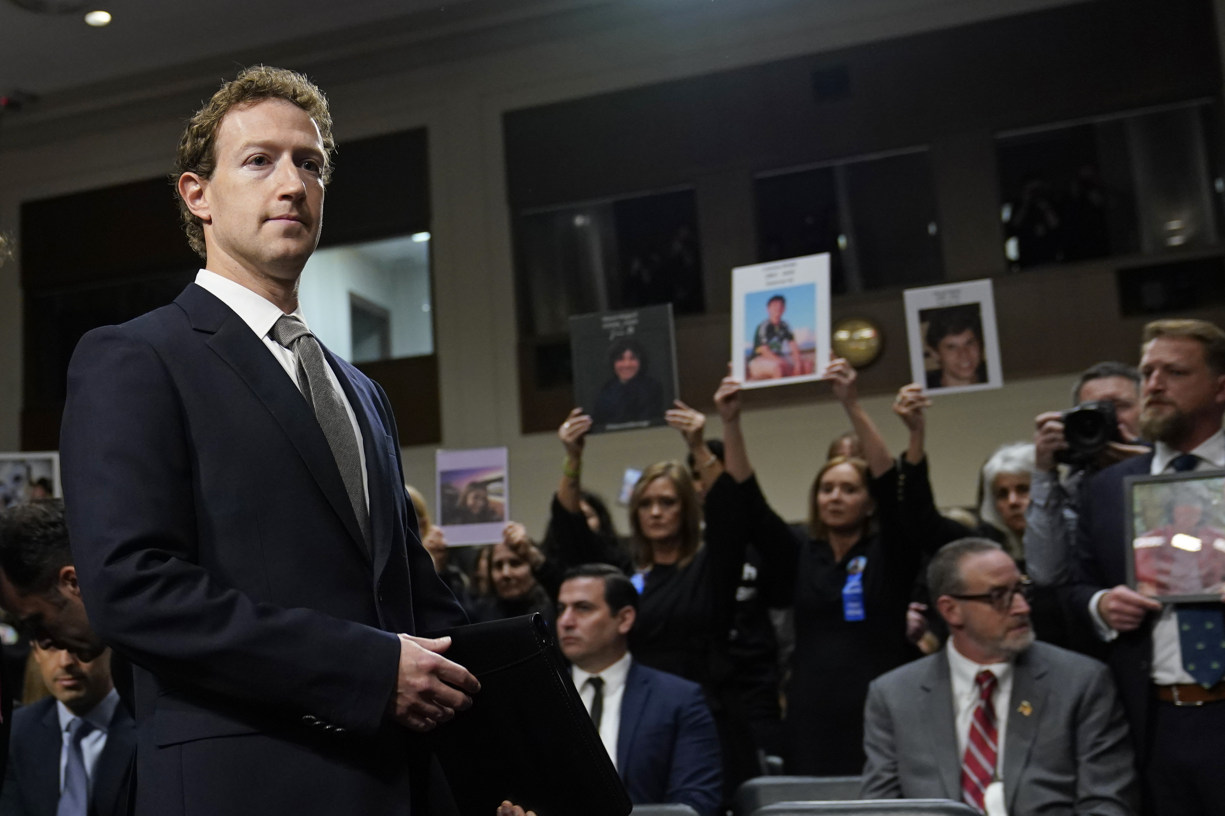 FILE - With people holding photos of their loved ones, Meta CEO Mark Zuckerberg arrives to testify before a Senate Judiciary Committee hearing on Capitol Hill in Washington, Jan. 31, 2024, to discuss child safety. (AP Photo/Susan Walsh, File)