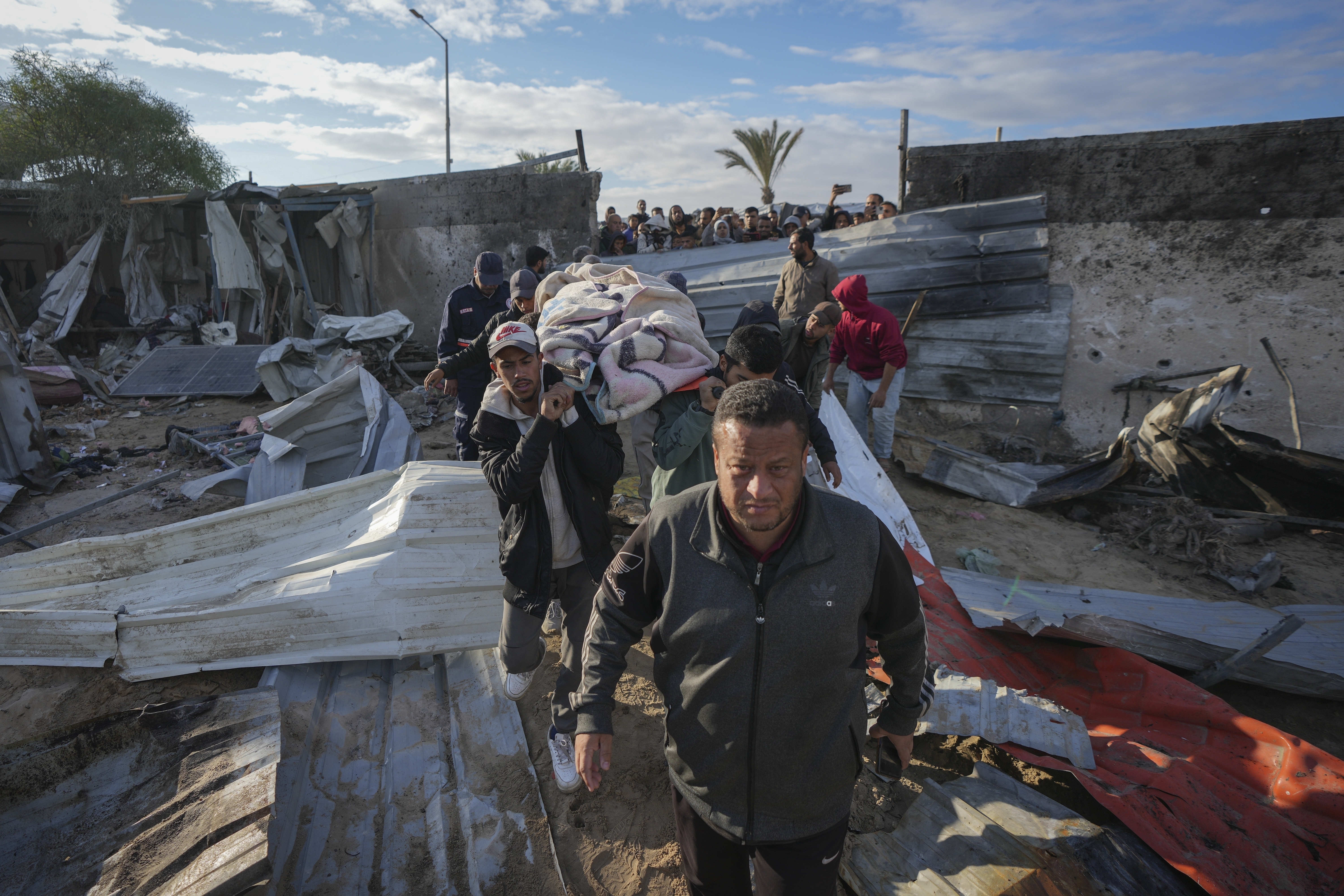 A body is recovered from the debris in the aftermath of an Israeli airstrike at the Muwasi camp near Khan Younis, in the southern Gaza Strip, on Thursday, Dec. 5, 2024. (AP Photo/Abdel Kareem Hana)