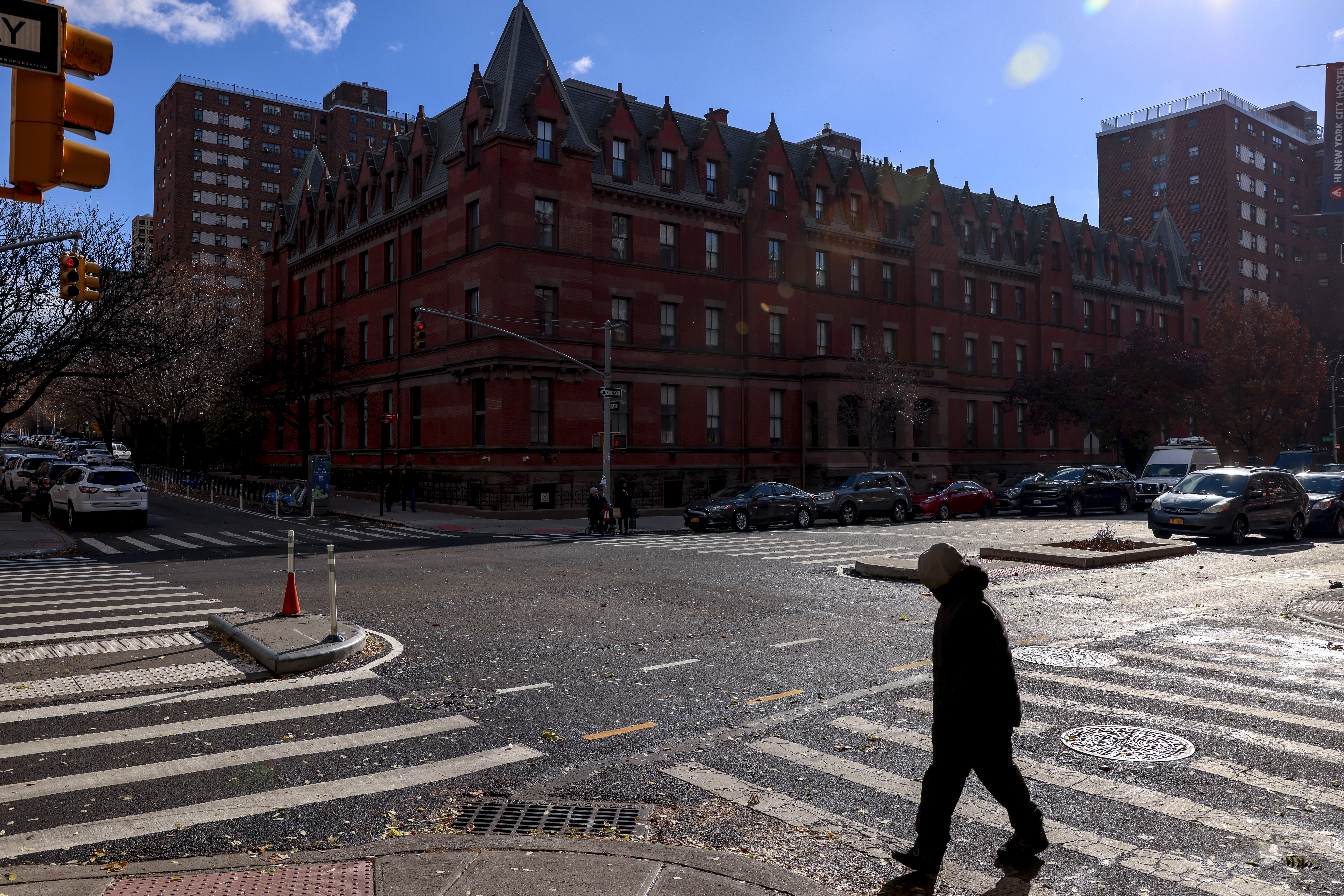 A man crosses the street outside the HI New York City hostel, Thursday, Dec. 5, 2024, in New York, where police say the suspect in the killing of UnitedHealthcare CEO Brian Thompson may have stayed.(AP Photo/Yuki Iwamura)